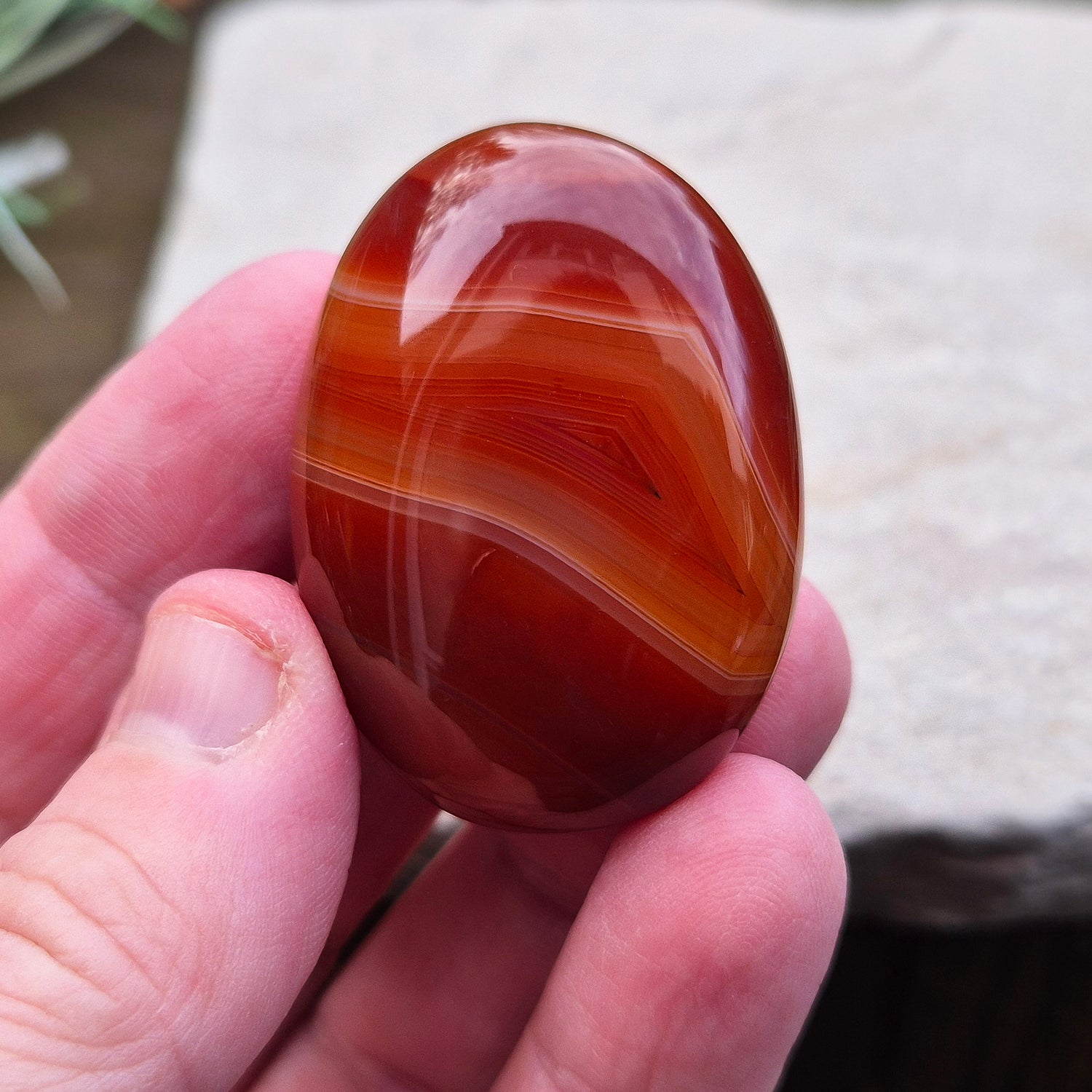 Carnelian Crystal Palm Stone. From Madagascar. This palm stone has a wonderful deep orange colouring and some banding.