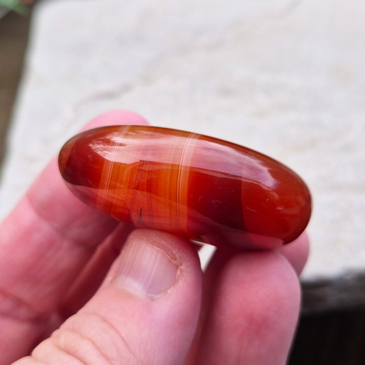 Carnelian Crystal Palm Stone. From Madagascar. This palm stone has a wonderful deep orange colouring and some banding.