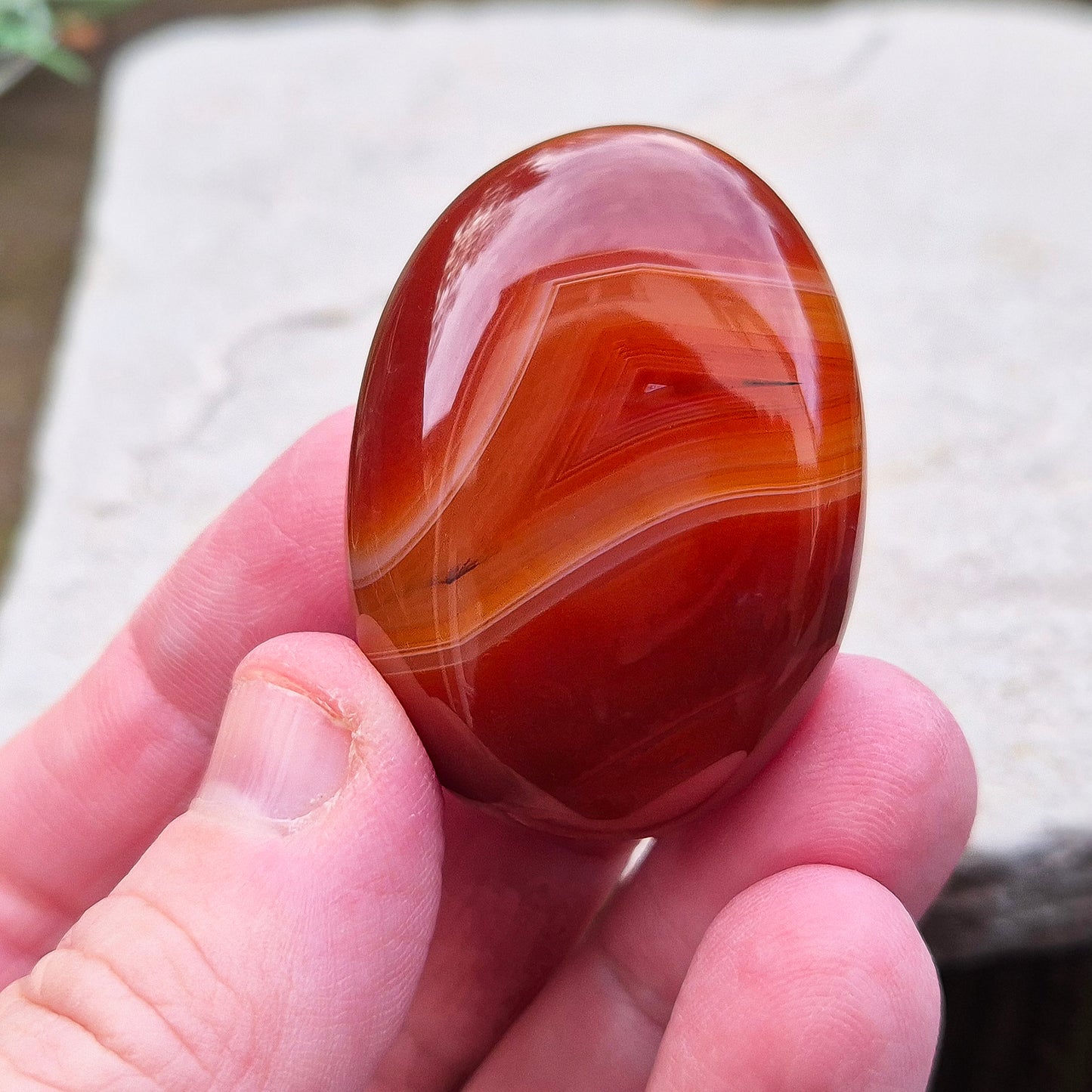 Carnelian Crystal Palm Stone. From Madagascar. This palm stone has a wonderful deep orange colouring and some banding.