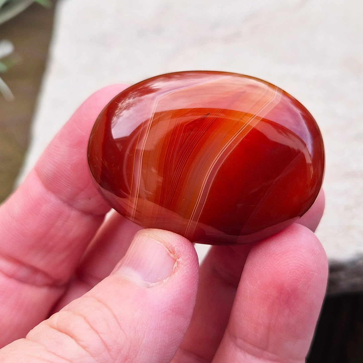 Carnelian Crystal Palm Stone. From Madagascar. This palm stone has a wonderful deep orange colouring and some banding.