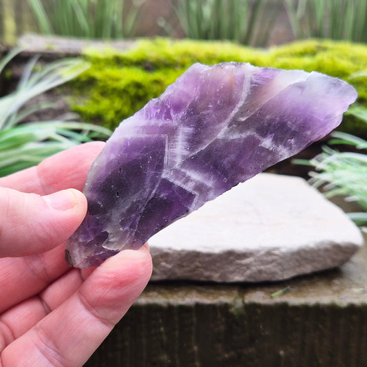 Chevron Amethyst Crystal Platform. One side is left untouched in its raw form, while the other is cut flat to create a versatile platform for displaying crystals,