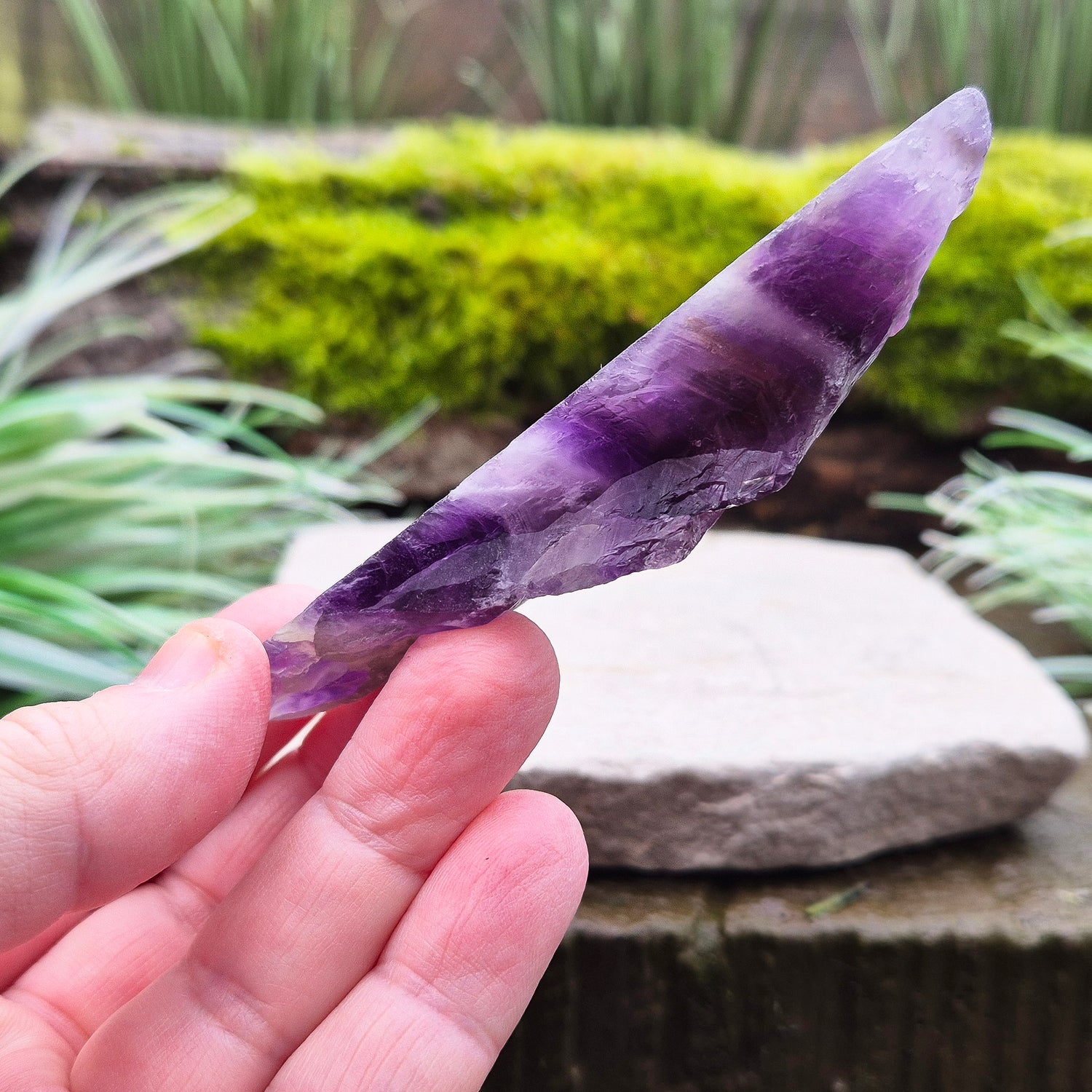 Chevron Amethyst Crystal Platform. One side is left untouched in its raw form, while the other is cut flat to create a versatile platform for displaying crystals,