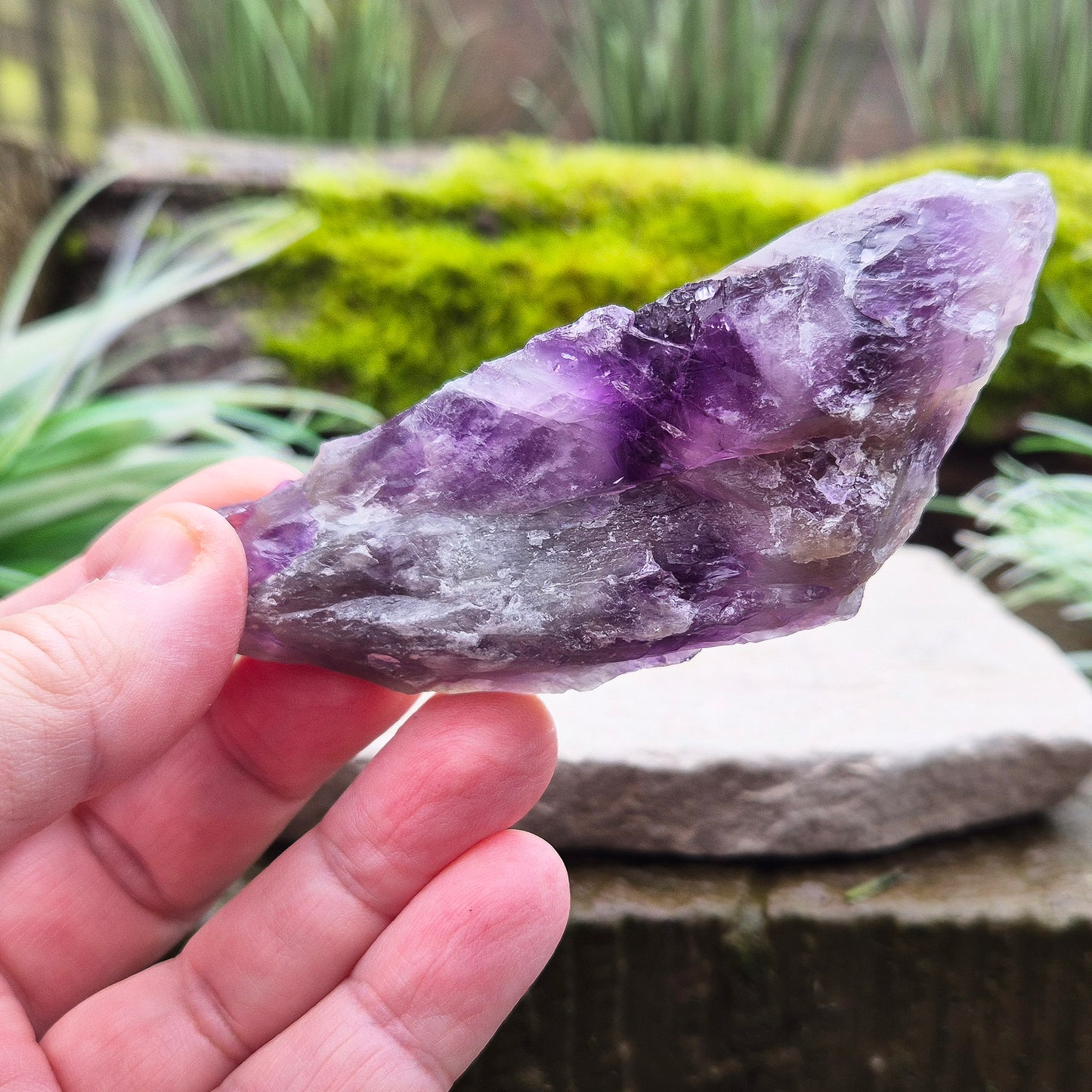 Chevron Amethyst Crystal Platform. One side is left untouched in its raw form, while the other is cut flat to create a versatile platform for displaying crystals,