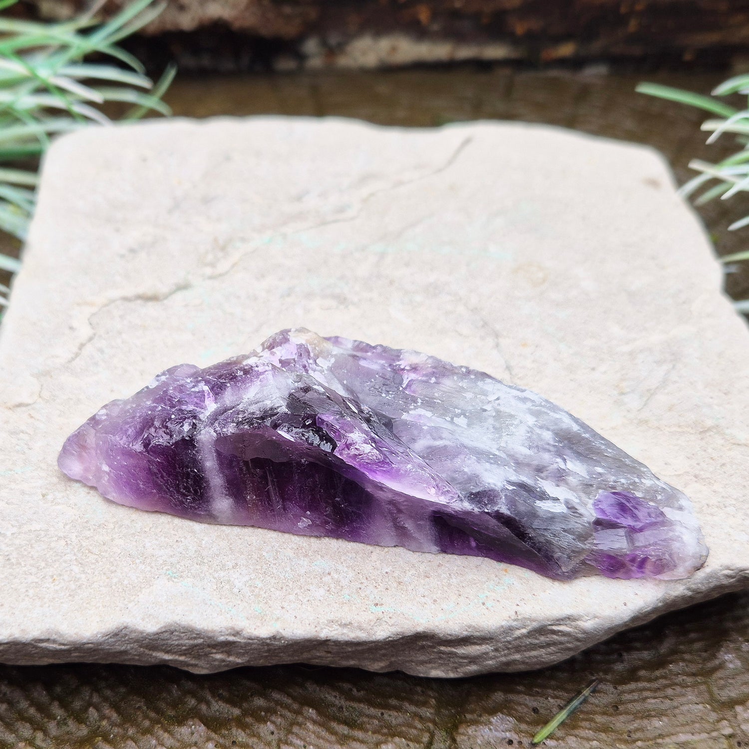 Chevron Amethyst Crystal Platform. One side is left untouched in its raw form, while the other is cut flat to create a versatile platform for displaying crystals,