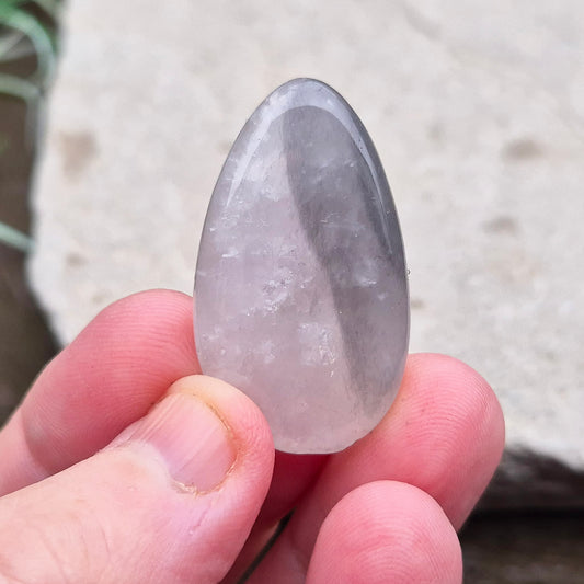 Lunar Rose Quartz Palm Stone, also known as Lunar Quartz, comes from Namibia. It is a blend of Rose Quartz and Graphite, creating unique color variations