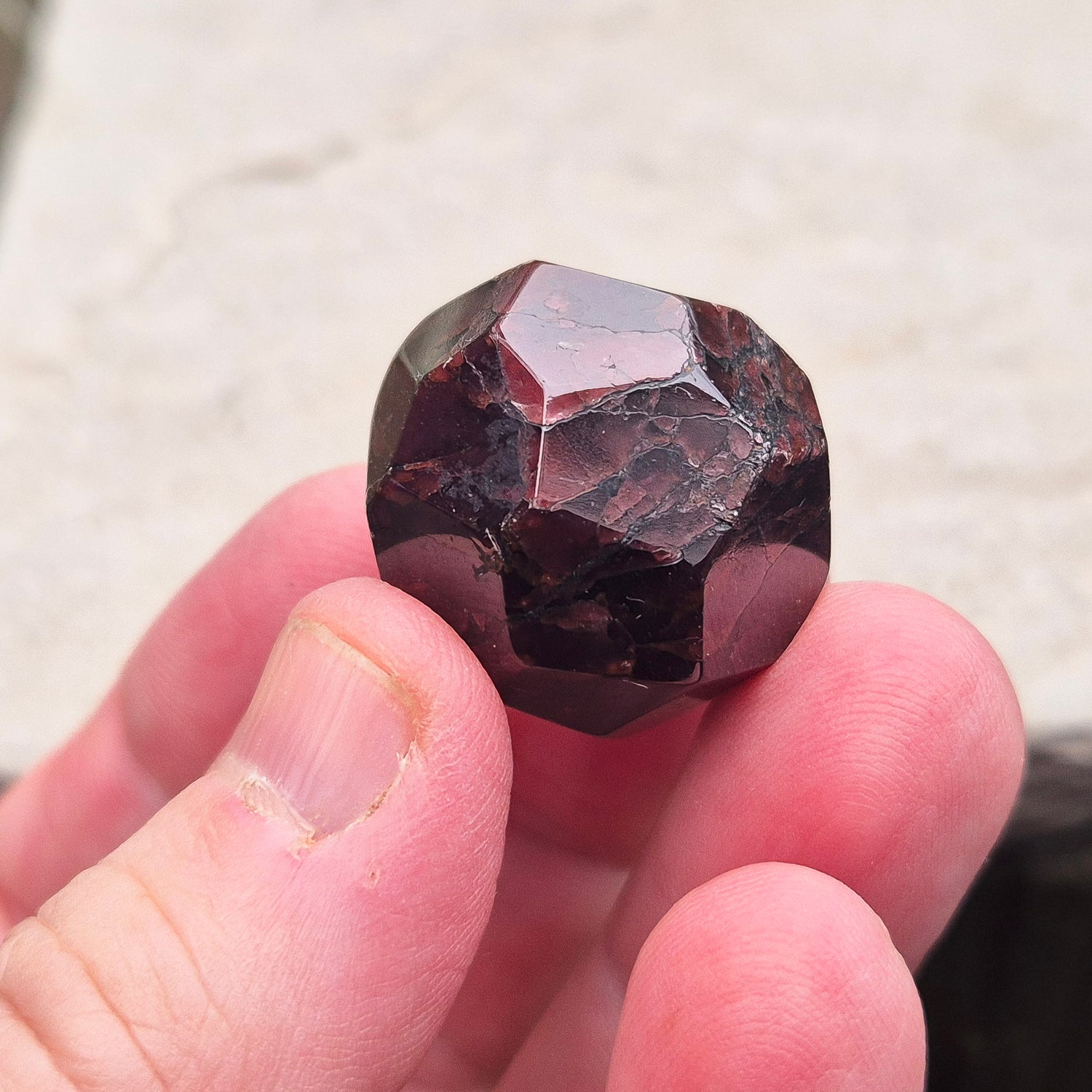 Almandine Garnet Crystal from India, featuring deep reddish-brown hues. Also known as Almandite, this variety of Garnet showcases rich colors ranging from dark reds to purple and brownish reds. 