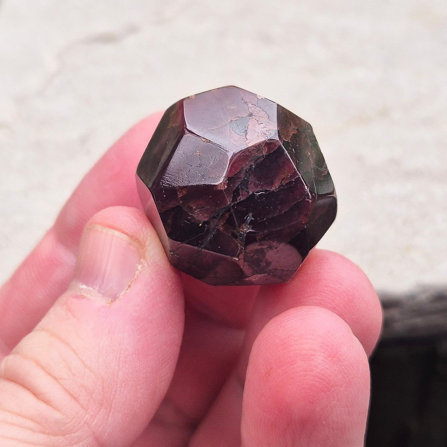 Almandine Garnet Crystal from India, featuring deep reddish-brown hues. Also known as Almandite, this variety of Garnet showcases rich colors ranging from dark reds to purple and brownish reds. 