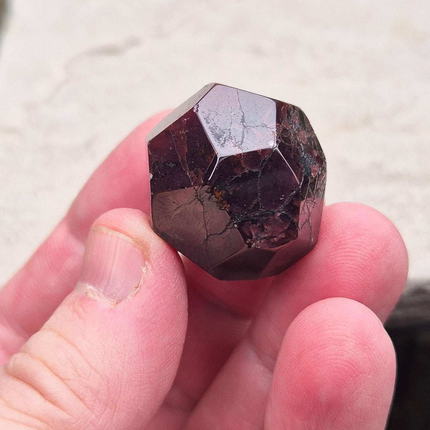 Almandine Garnet Crystal from India, featuring deep reddish-brown hues. Also known as Almandite, this variety of Garnet showcases rich colors ranging from dark reds to purple and brownish reds. 