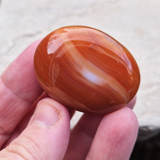 Carnelian Crystal Palm Stone. From Madagascar. This palm stone has a wonderful orange and white banded colouring.