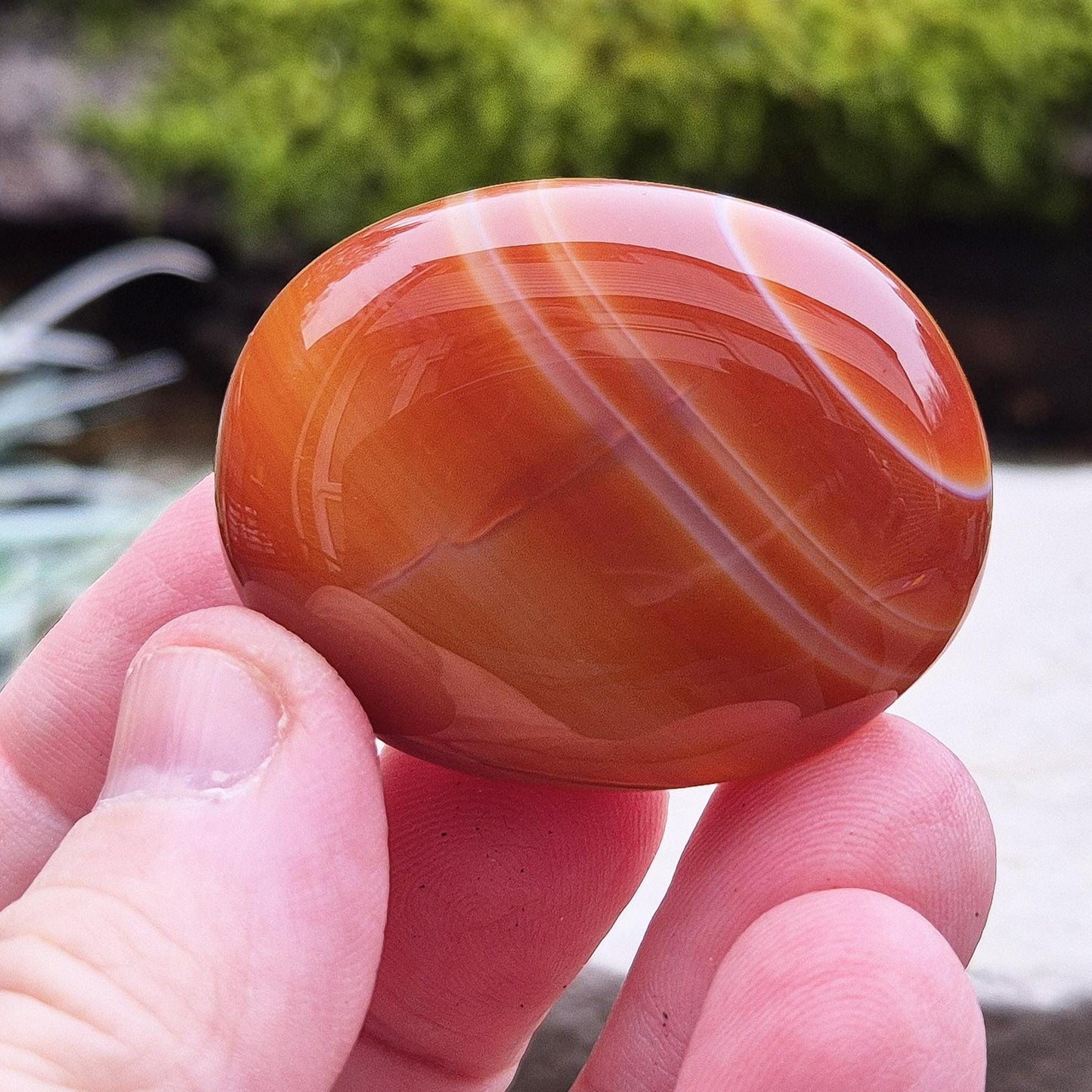 Carnelian Crystal Palm Stone. From Madagascar. This palm stone has a wonderful orange colour and some banding.