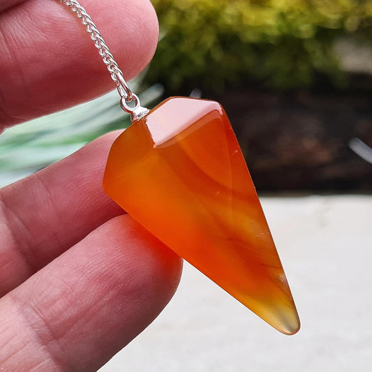 Carnelian Crystal Pendulum. From Madagascar. This pendulum has great orange colouring, and it has a druzy pocket towards the tip which is really unusual. 