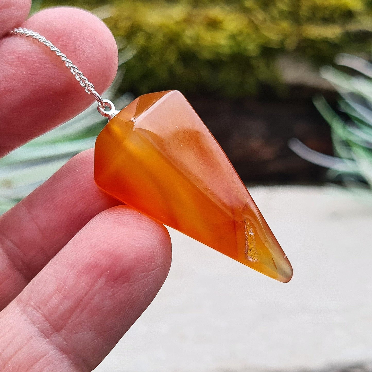 Carnelian Crystal Pendulum. From Madagascar. This pendulum has great orange colouring, and it has a druzy pocket towards the tip which is really unusual. 