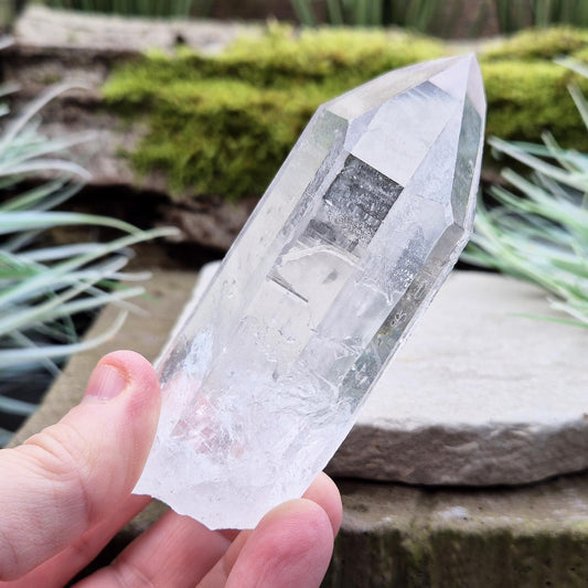 Quartz Crystal Point with etchings on at least of the sides. From Brazil. This is a wonderfully natural quartz point with nice clear clarity.