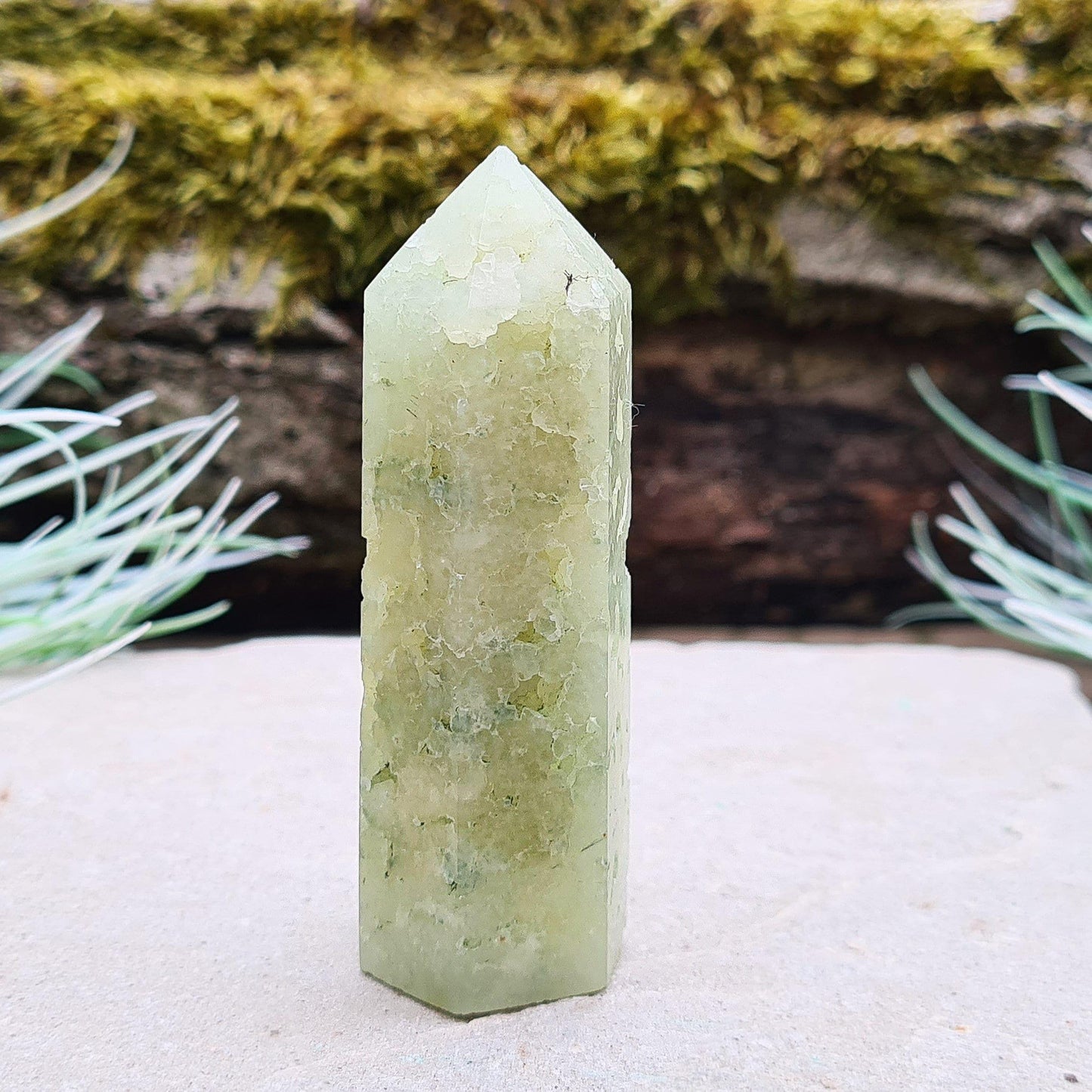 Prehnite Crystal Tower, point is a 6 sided Generator, has lovely natural cavities so you can see the crystalline structure within it. The prehnite is a lovely green. 