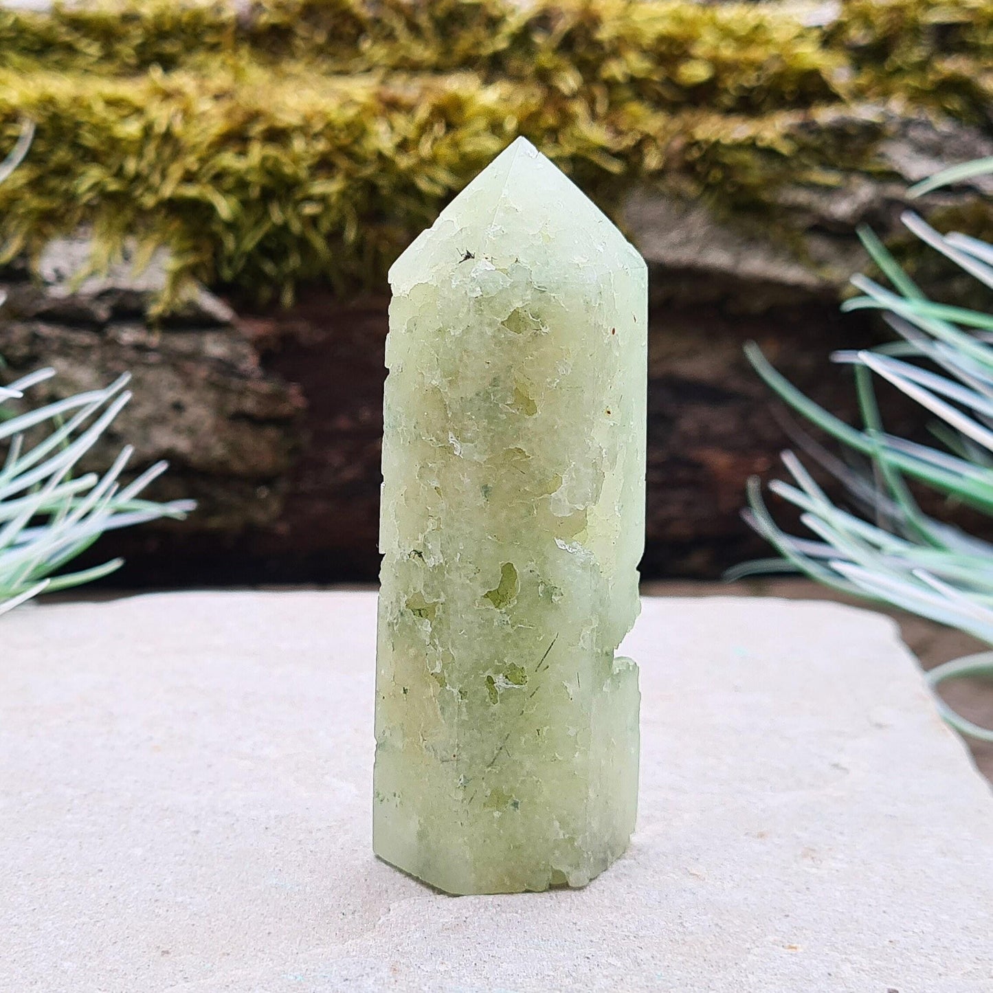 Prehnite Crystal Tower, point is a 6 sided Generator, has lovely natural cavities so you can see the crystalline structure within it. The prehnite is a lovely green. 