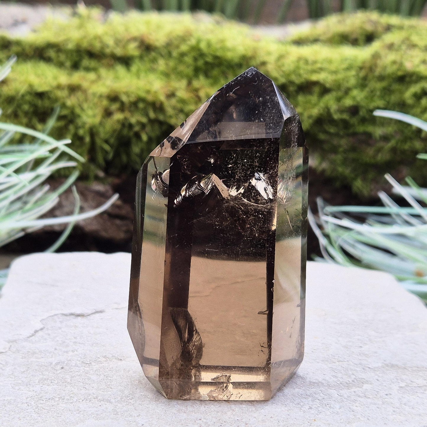 Smoky Quartz Point from Brazil. Natural dark Smoky Quartz polished point. This point has been cut and polished in Brazil. This piece has light reflecting inclusions. 