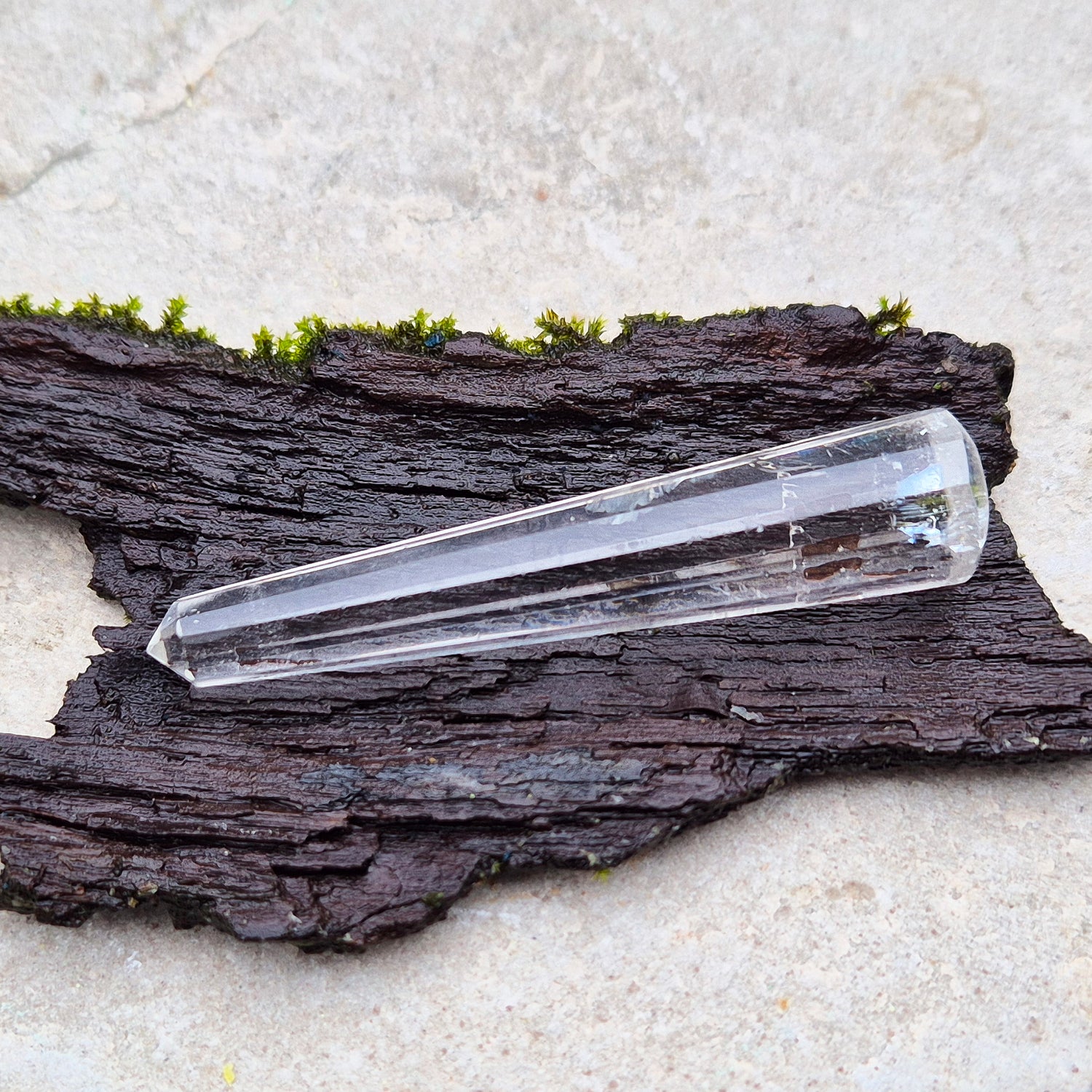 Mini Vogel Quartz Crystal Wand with 12 sides, pointed tip and rounded base, from Brazil. Has great clarity and a light reflecting inclusion at the base.