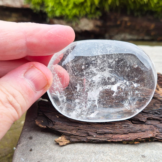 This beautifully polished Clear Quartz palm stone fits comfortably in the hand. Has light reflecting inclusions within it which catch the light.