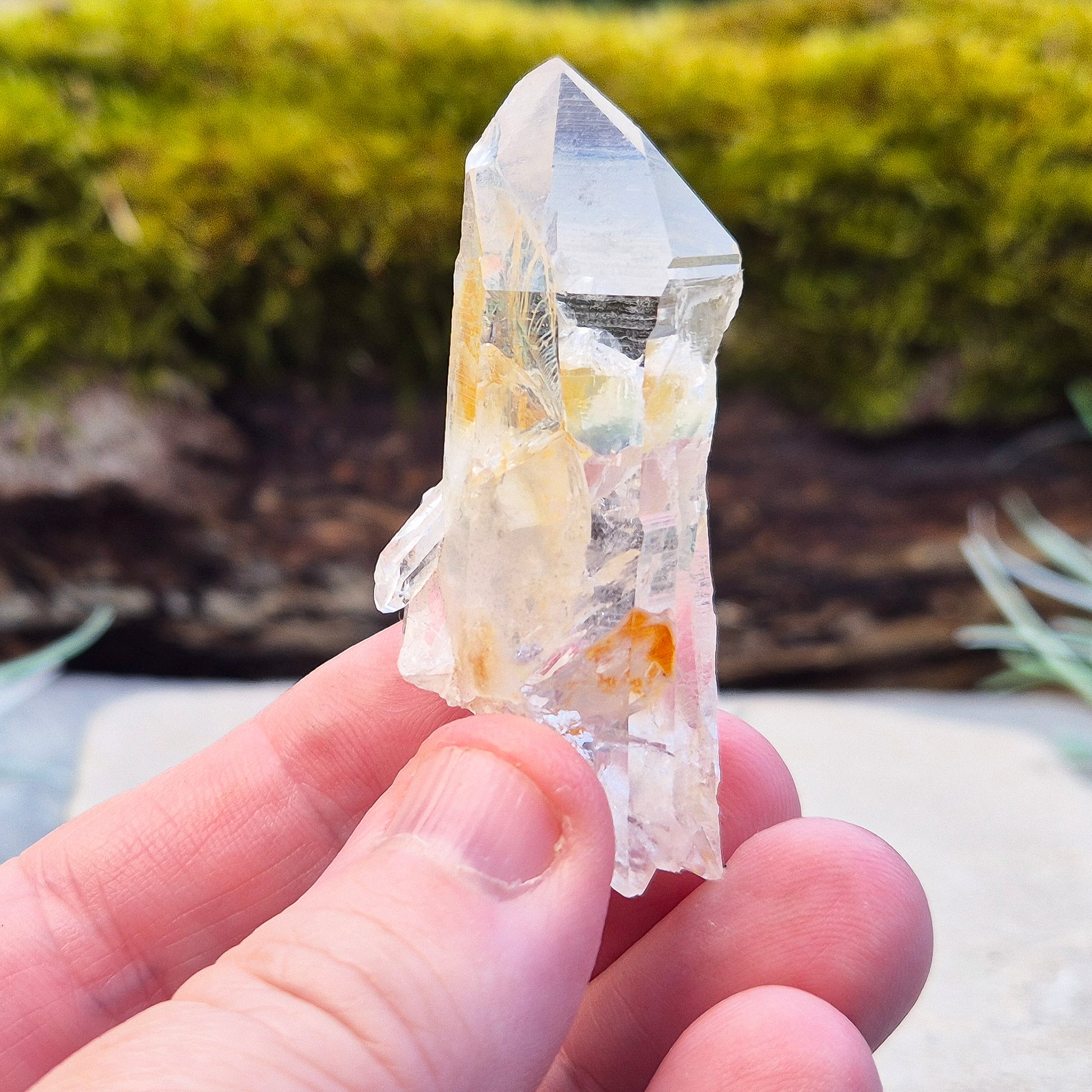 This rare Blade of Light Quartz is a striking Lemurian Quartz from the mountains of Colombia. Known for its exceptional clarity and natural brilliance, this piece features a point that has a few smaller crystals growing out of/into it. 