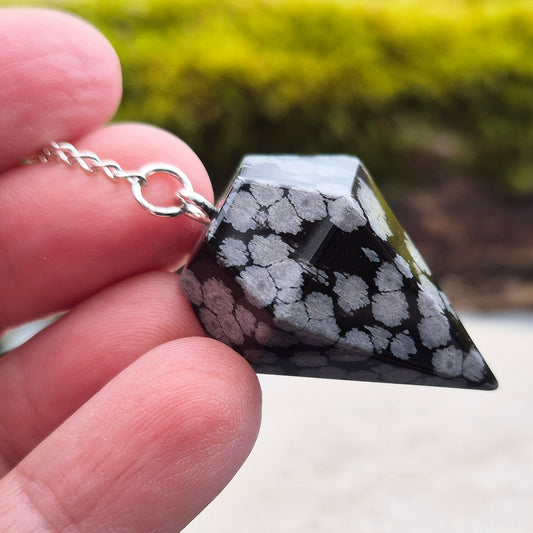 Snowflake Obsidian Crystal Pendulum from the USA. Comes in a organza pouch to keep it in. Chain has a metal ring at the end of it.