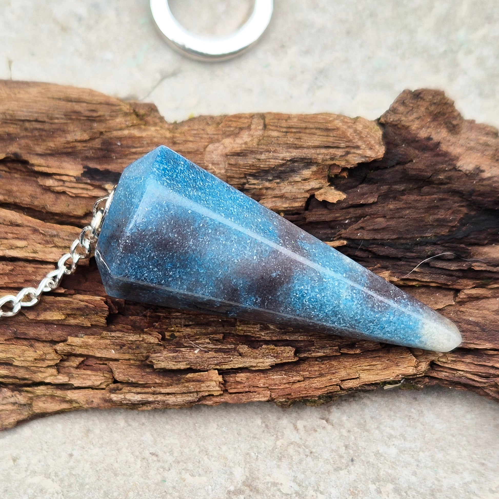 Trolleite Crystal Pendulum. From Brazil. Chain has a silver ring at the end of it. Comes in a box or pouch to keep it in.