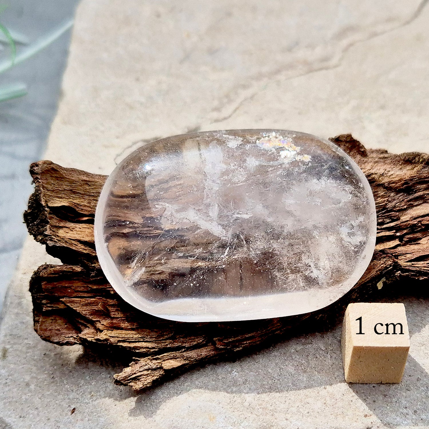 This beautifully polished Clear Quartz palm stone fits comfortably in the hand. Has light reflecting inclusions within it which catch the light.