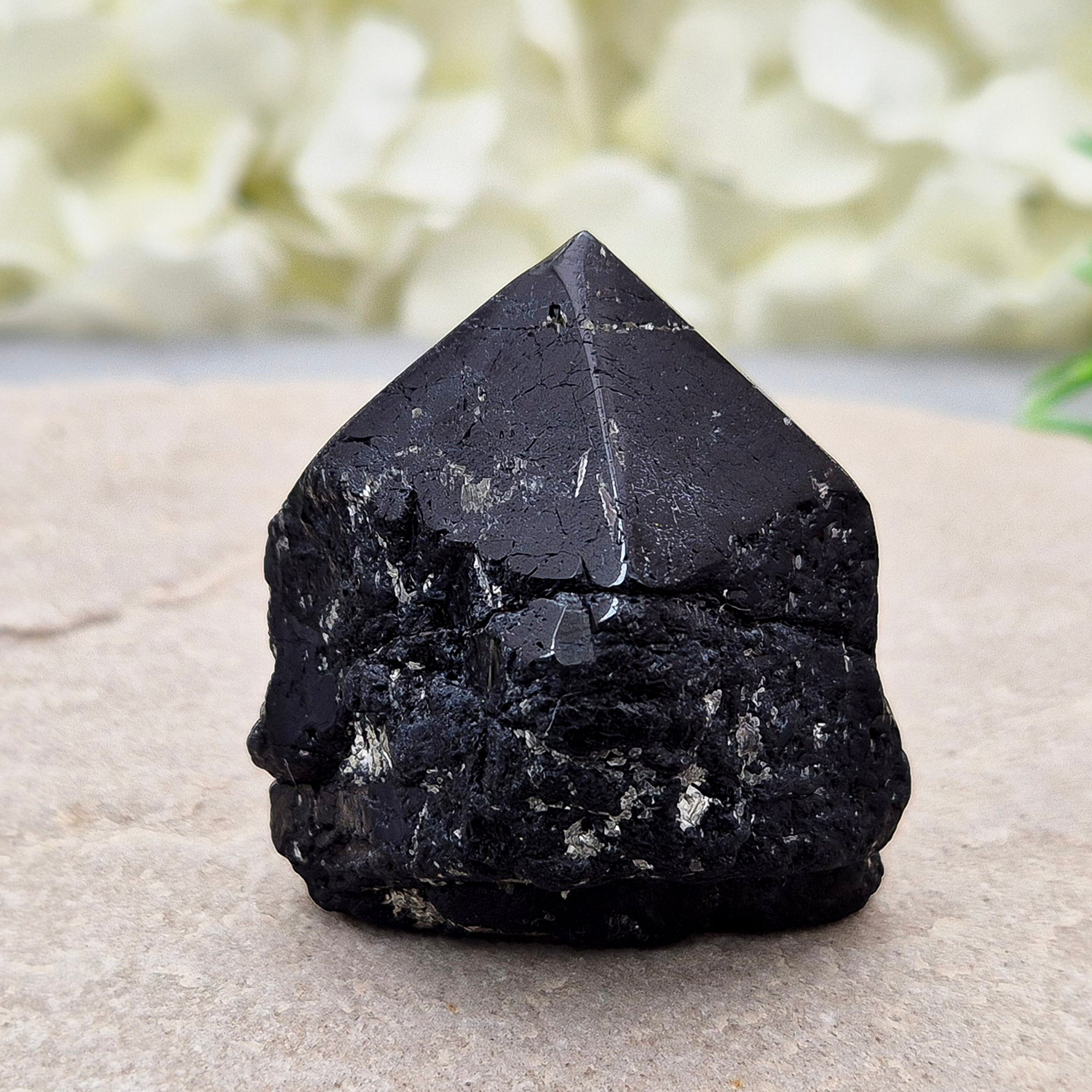 Black Tourmaline point from Brazil, which has polished tip, natural sides and cut flatbase. Contains a few sparkly Mica inclusions. A perfect piece for anyone needing strong protection, energetic clarity, and emotional strength.