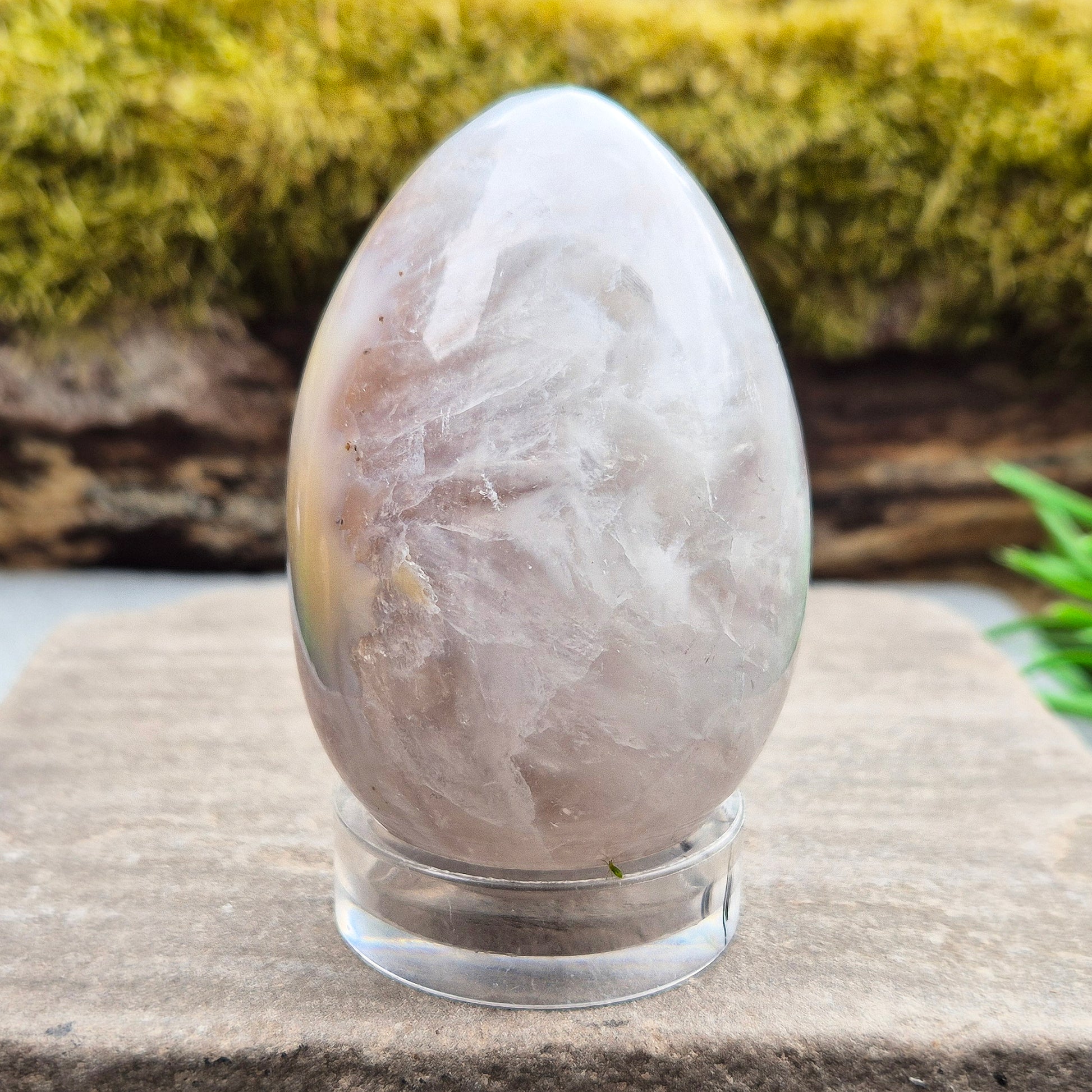 This beautiful Druzy Agate egg from Brazil is polished and showcases a sparkling pocket of natural druzy crystals in the middle of it. It comes with a clear acrylic stand, making it a lovely addition to any space or crystal shelf. Its soft, steady energy brings emotional calm, grounding, and quiet strength.
