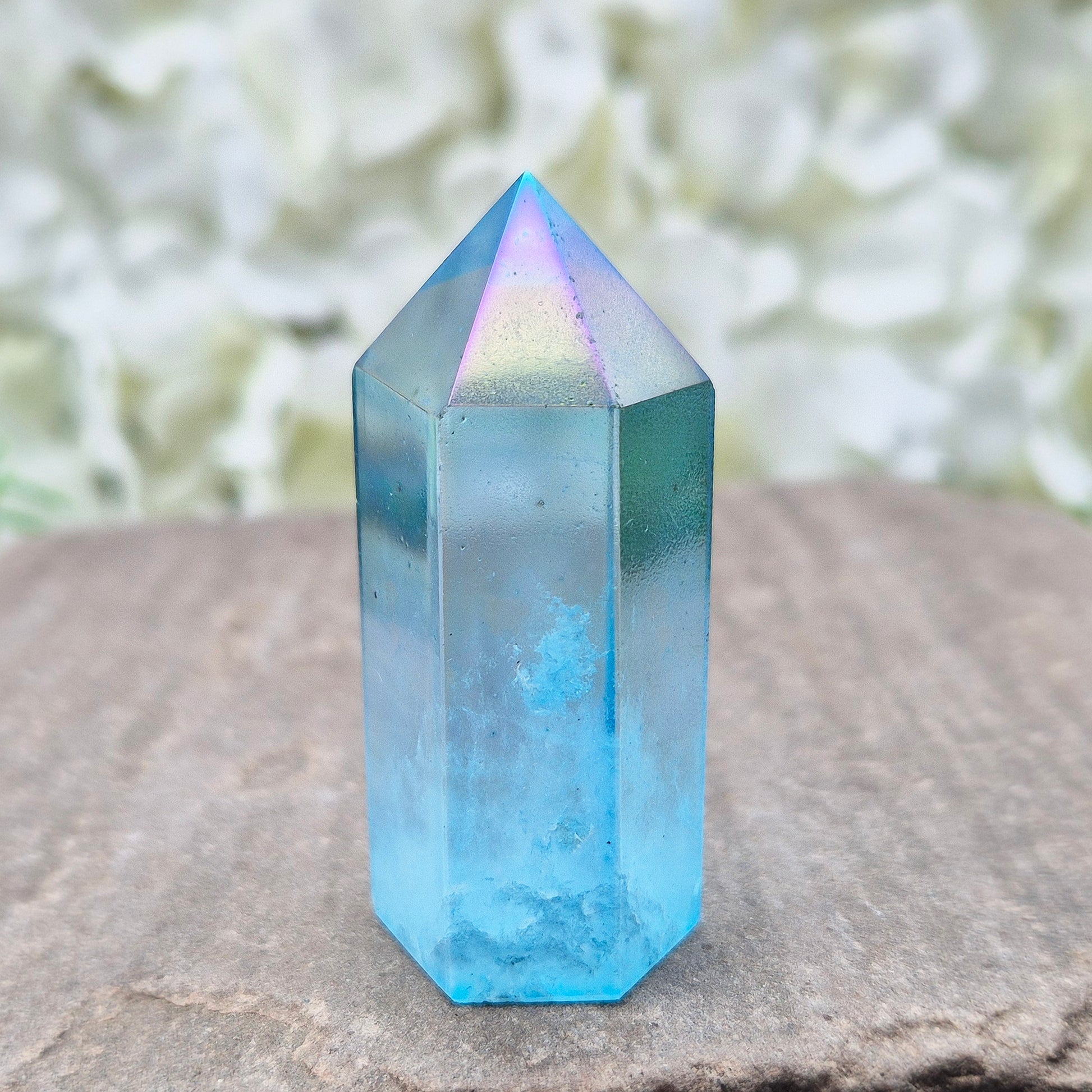 This beautiful Aqua Aura Quartz Standing Point from Brazil has an electric blue sheen with soft rainbow flashes, created by bonding pure gold to Quartz in a special heat process. The result is a striking crystal with a bright, peaceful energy. 