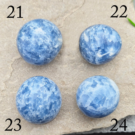 This polished Blue Calcite crystal from Madagascar has a lovely blue colouring and a rounded, gently domed shape that fits naturally into the palm. It carries a comforting, wave-like energy — peaceful, steady, and easy to be around.