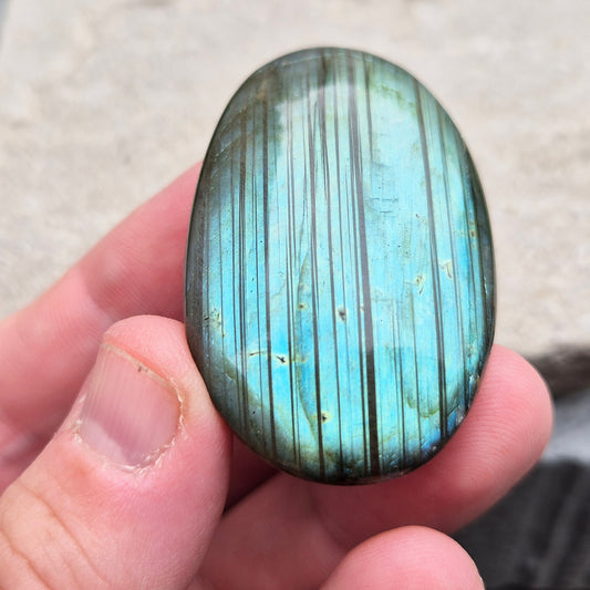 This Labradorite palm stone catches the light with a stunning array of flashes of blue/green.