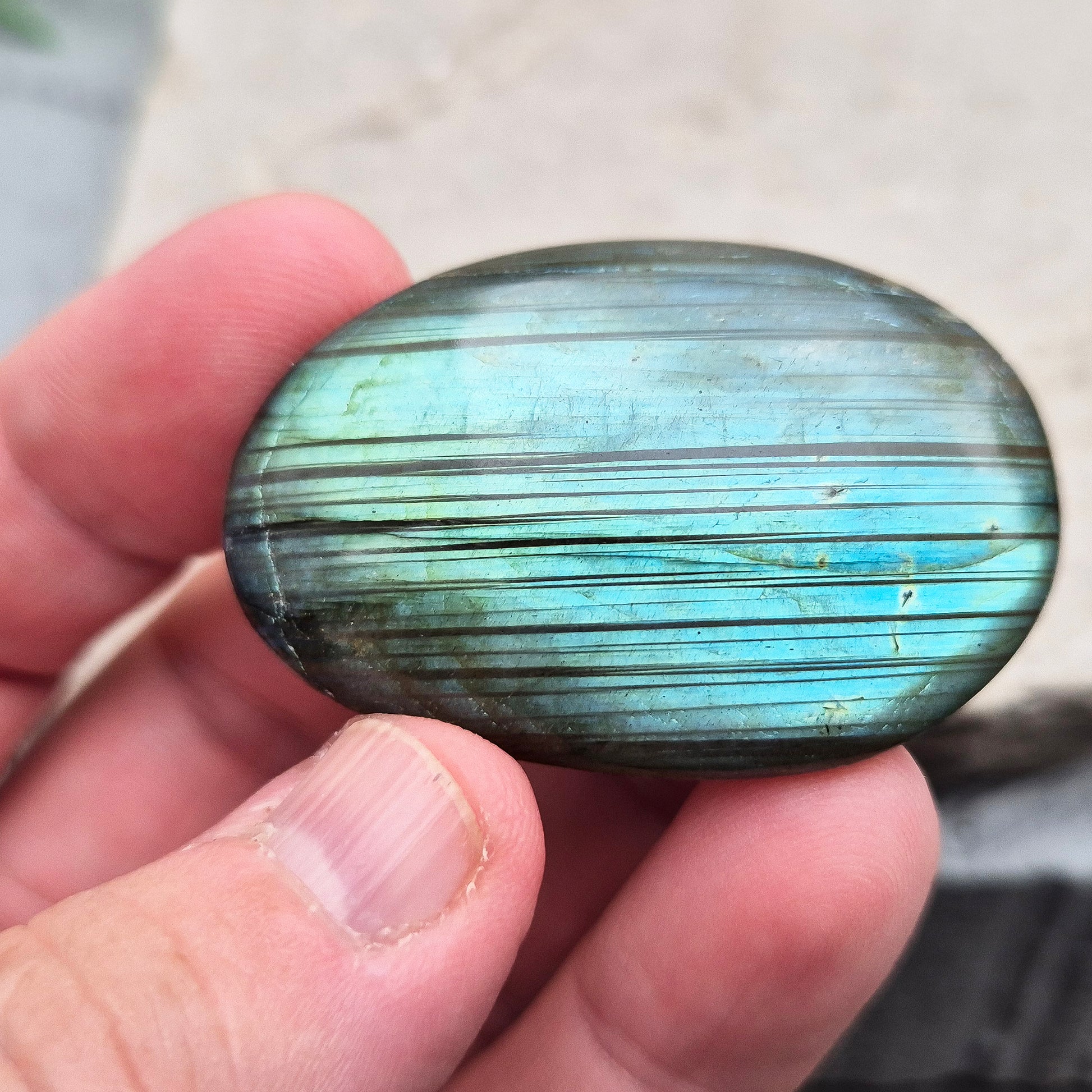 This Labradorite palm stone catches the light with a stunning array of flashes of blue/green.