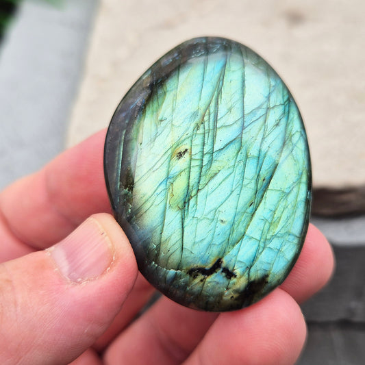 This Labradorite palm stone catches the light with a stunning array of flashes of blue/green.