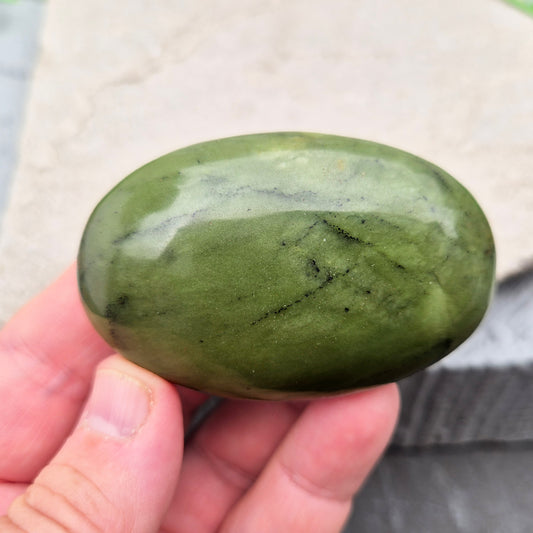 This smooth, polished Nephrite Jade palm stone from Pakistan features classic deep green tones. Nephrite Jade has long been seen as a stone of luck and wellbeing — but it's also a true ally for emotional balance and inner strength. 