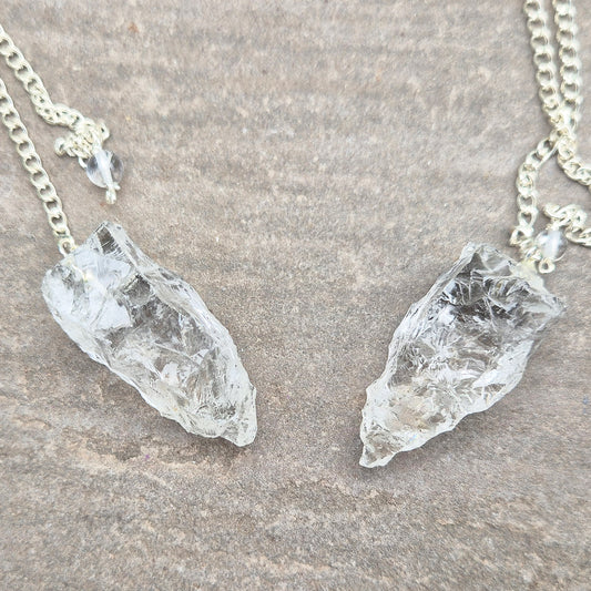 This Rock Quartz Crystal Pendulum from Brazil features a natural quartz crystal and a white bead at the end of the chain.