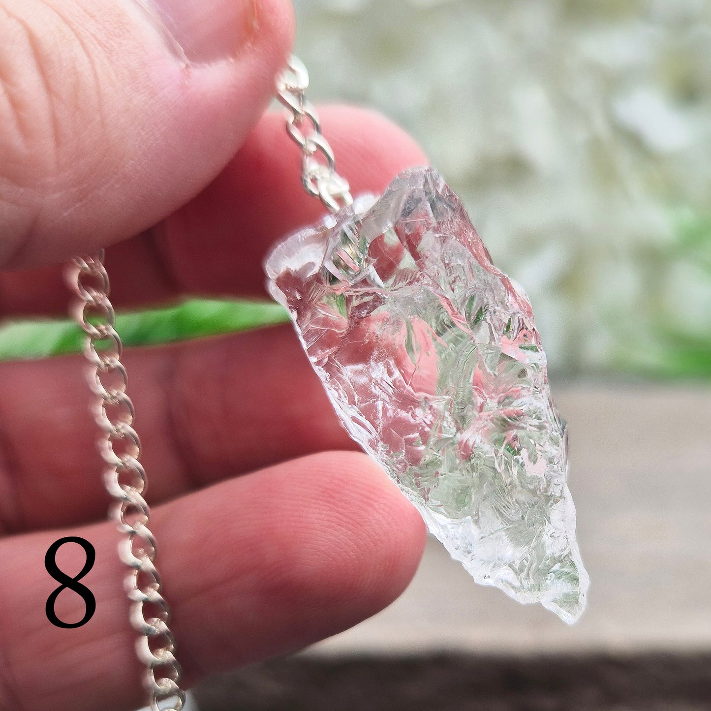 This Rock Quartz Crystal Pendulum from Brazil features a natural quartz crystal and a white bead at the end of the chain.
