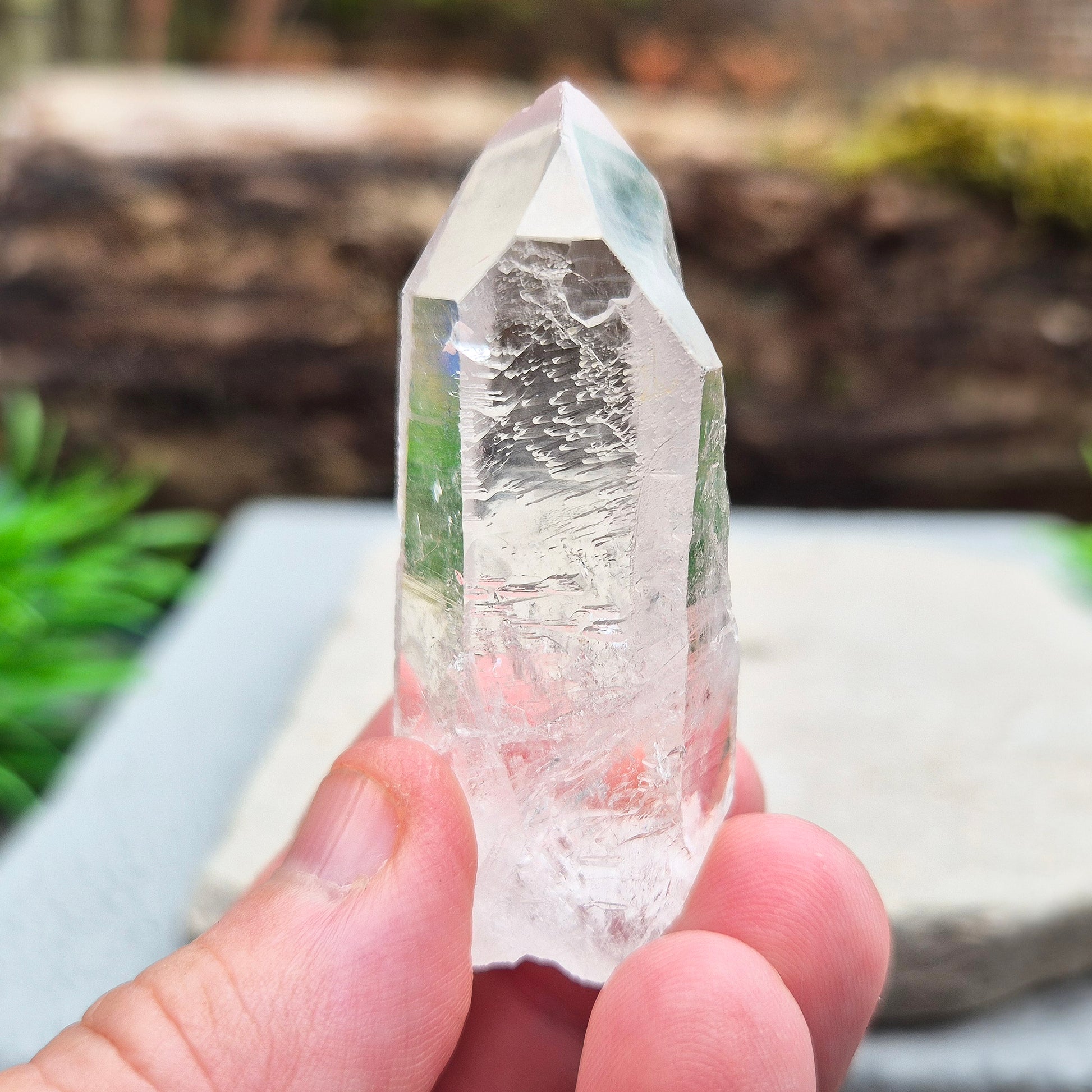 This natural quartz point has lovely clarity with Starbrary markings on at least two sides. These etched shapes — triangles, lines, and patterns — look like ancient writing and are thought to carry cosmic knowledge. 