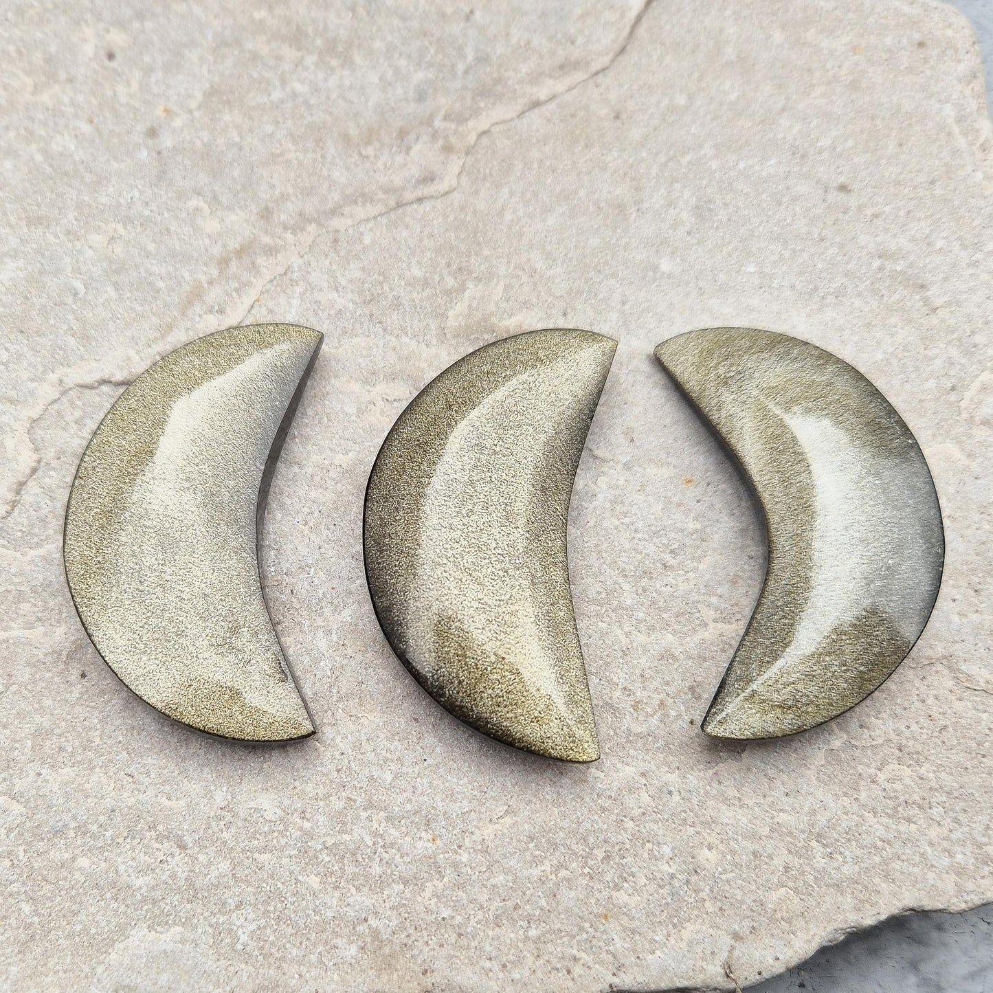 Gold Sheen Obsidian crescent moons from Mexico. Protective and empowering crystals that reveal truth, clear energy, and attract confidence and prosperity.