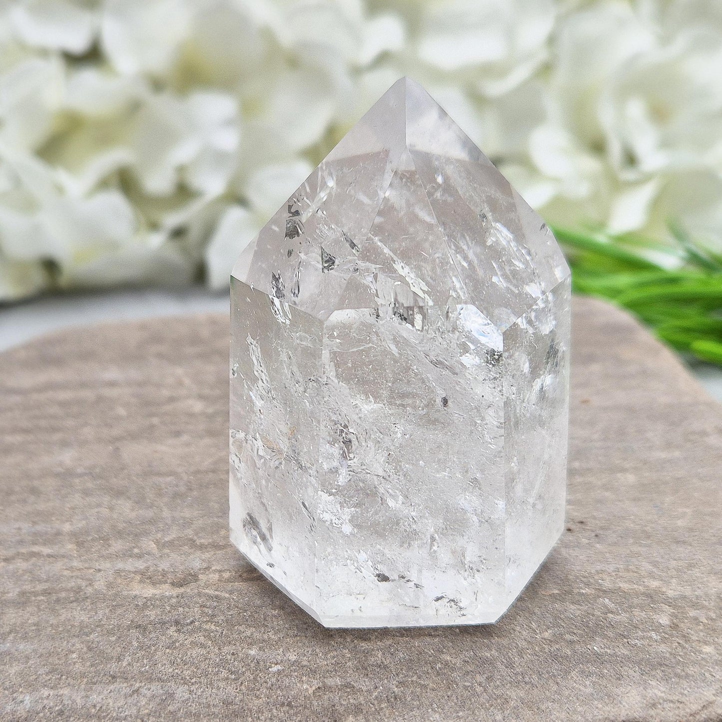 Polished Clear Quartz point from Brazil with sparkling inclusions. High vibration, versatile energy—perfect for clarity, healing, and spiritual focus. 