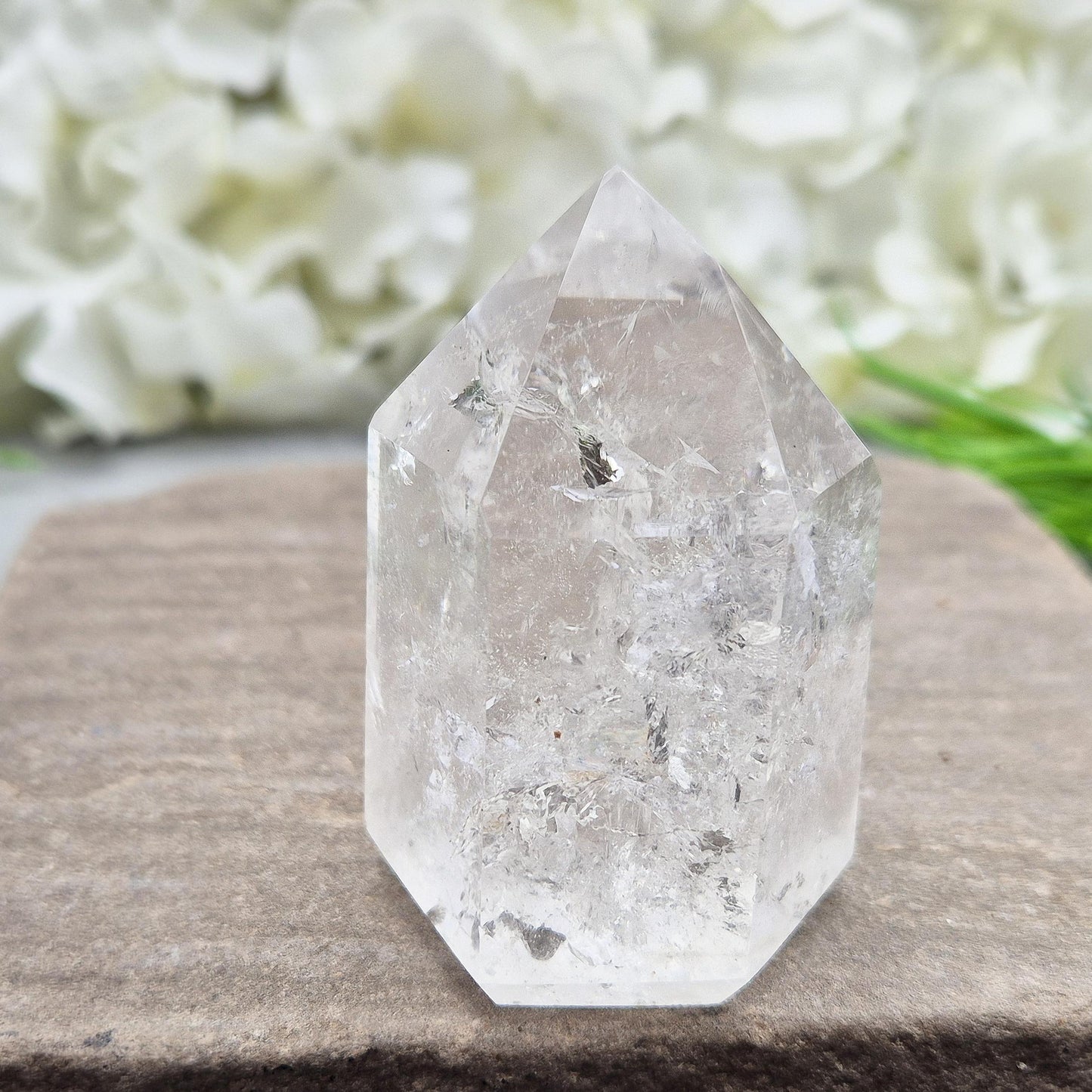 Polished Clear Quartz point from Brazil with sparkling inclusions. High vibration, versatile energy—perfect for clarity, healing, and spiritual focus. 