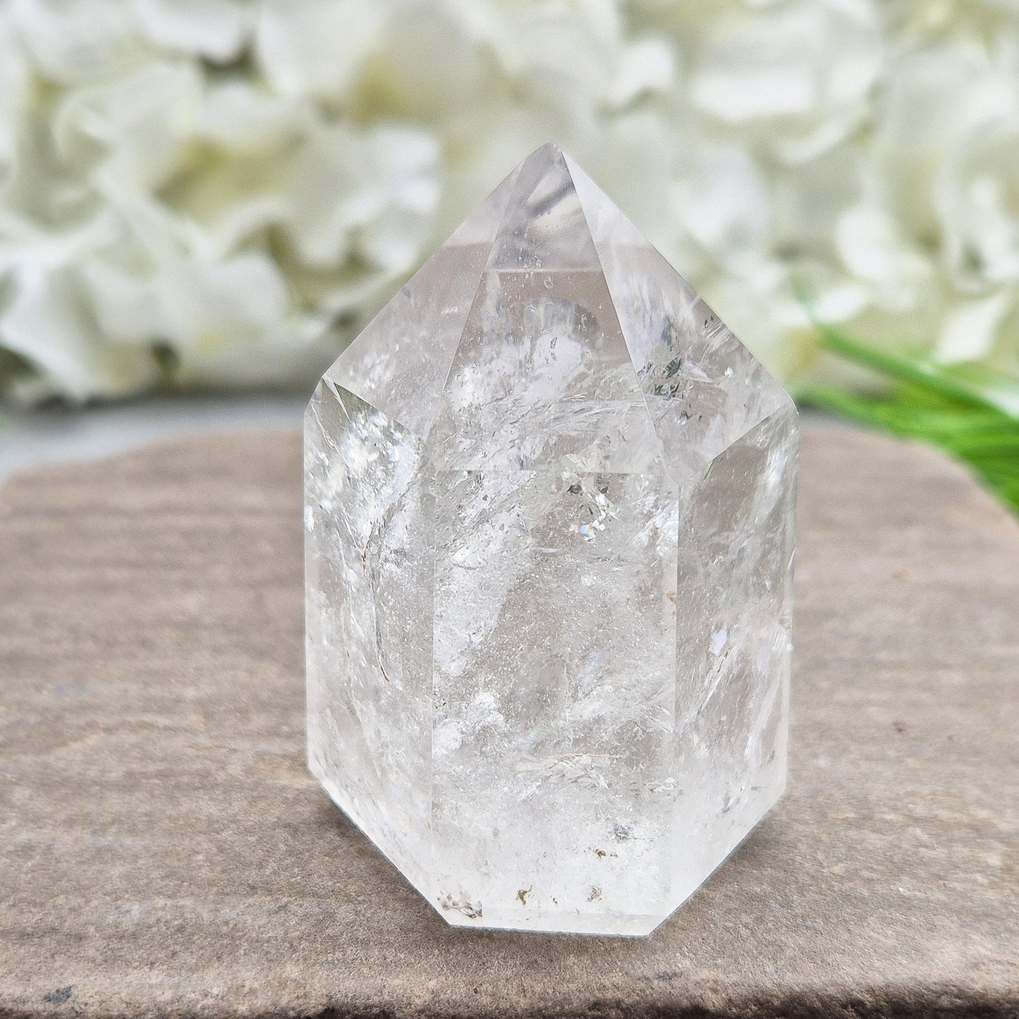 Polished Clear Quartz point from Brazil with sparkling inclusions. High vibration, versatile energy—perfect for clarity, healing, and spiritual focus. 