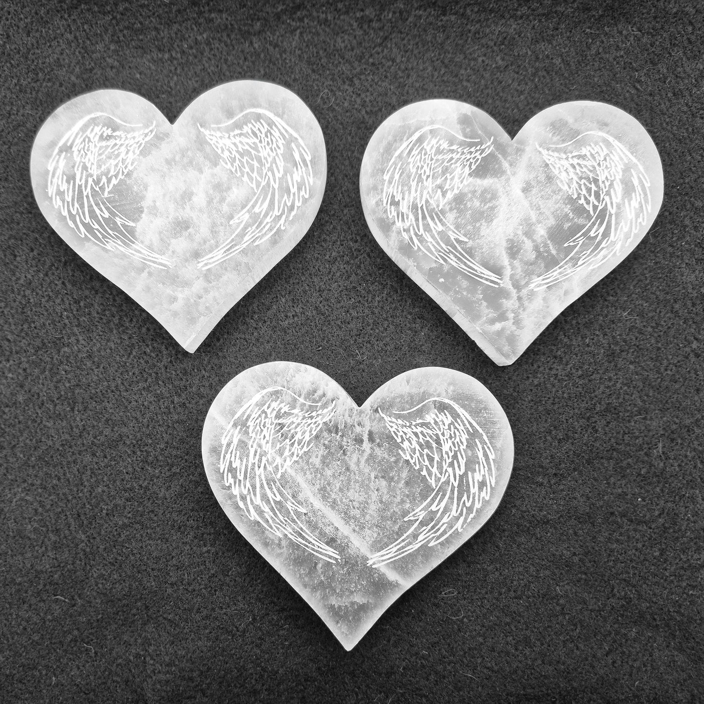 Selenite Heart Shaped Tiles etched with Angel Wings – A polished, serene crystal that adds tranquility and beauty to any space, perfect for uplifting energy.
