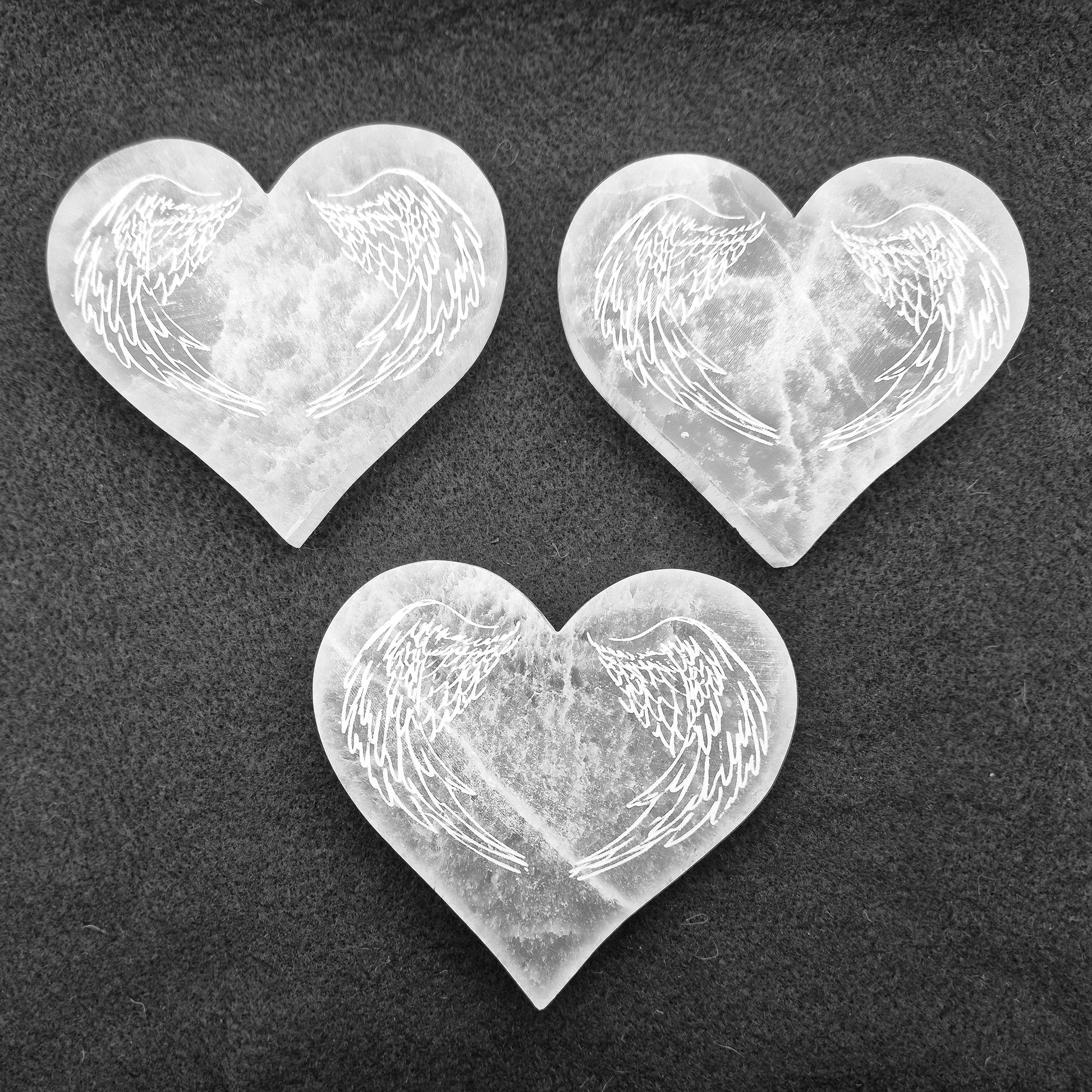 Selenite Heart Shaped Tiles etched with Angel Wings – A polished, serene crystal that adds tranquility and beauty to any space, perfect for uplifting energy.