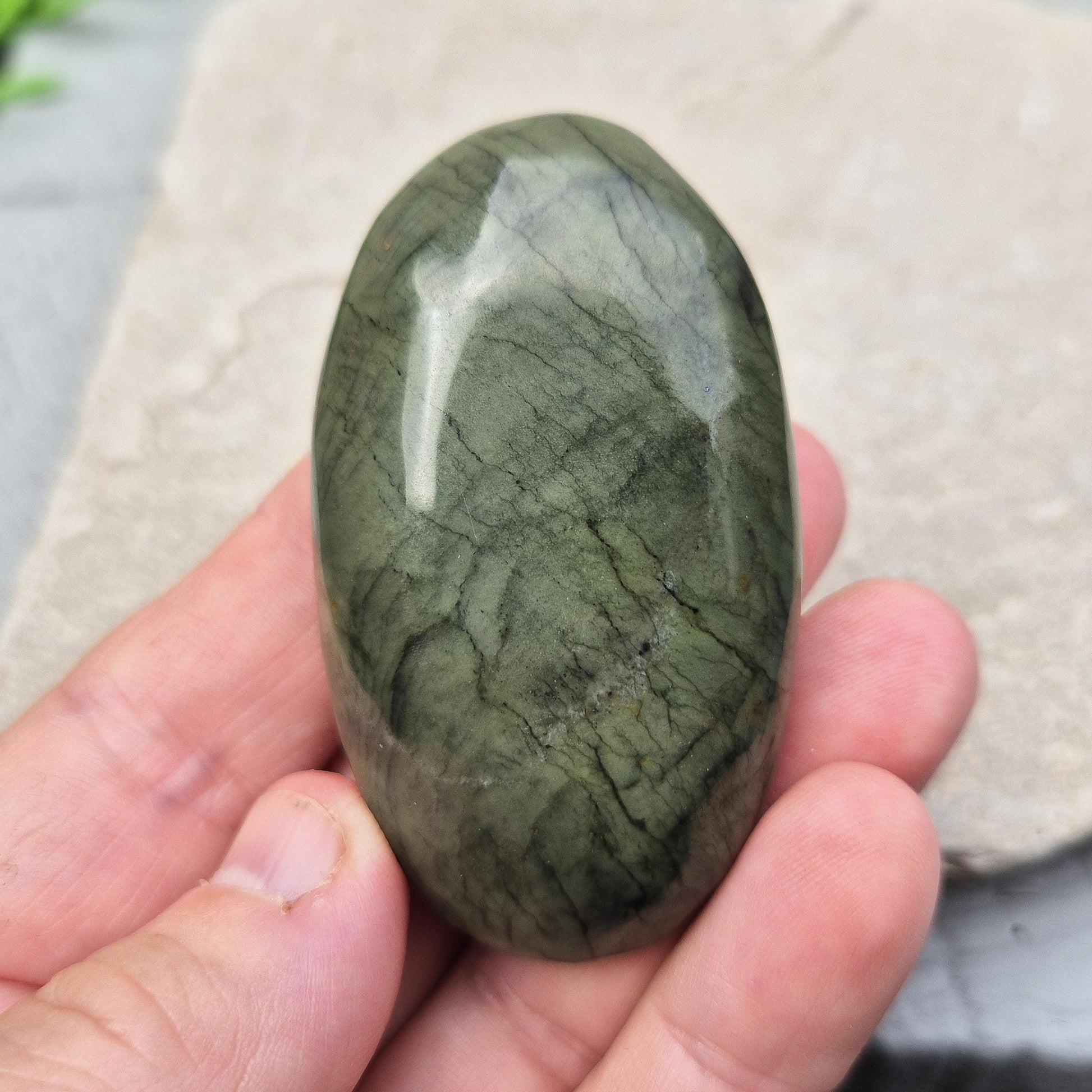 Polished Nephrite Jade palm stone from Pakistan. Deep green tones with grounding, peaceful energy. A timeless symbol of prosperity, strength, and renewal.