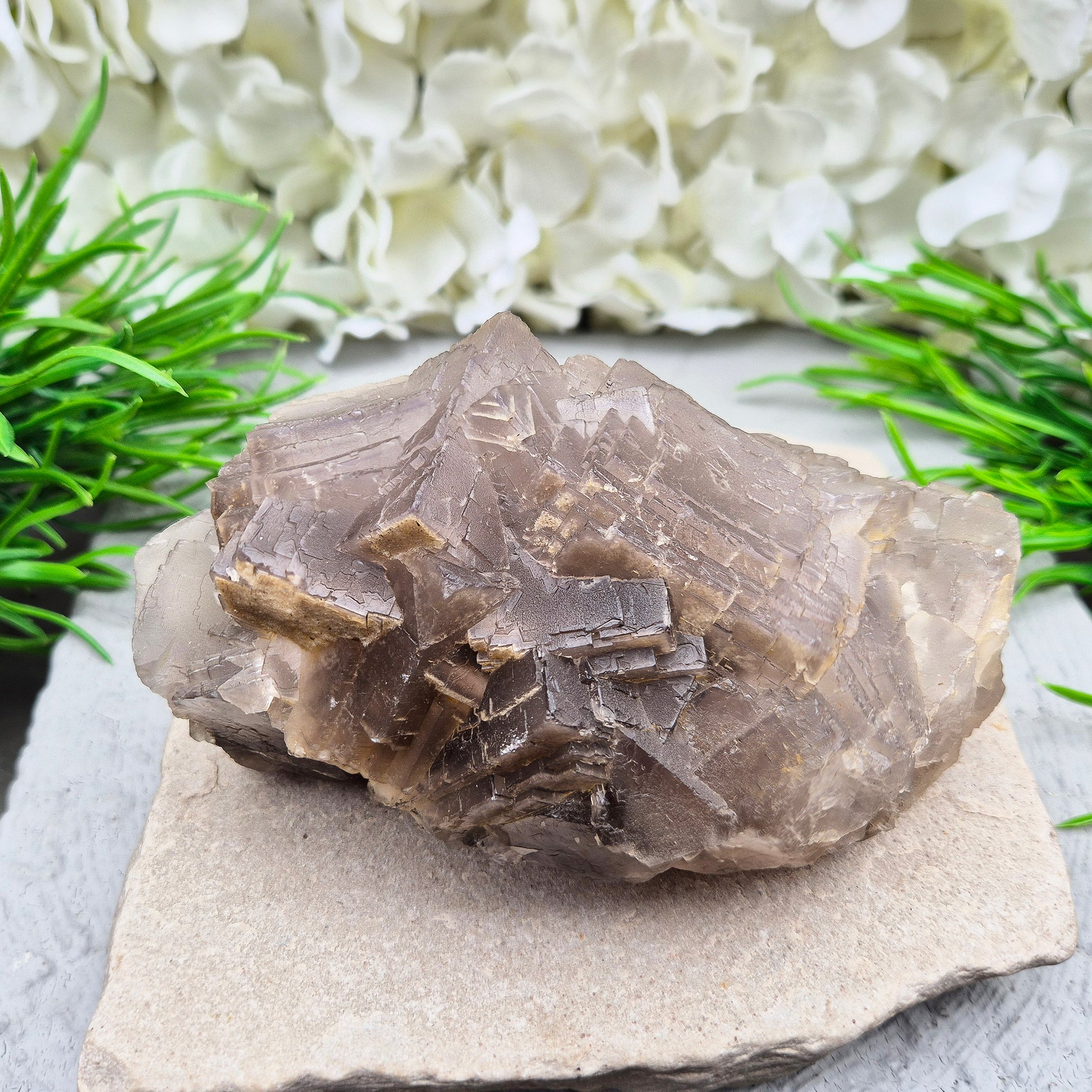 Cimmerian Fluorite cluster from Pakistan with soft smoky-grey tones. A calm, grounding crystal that supports focus, balance, and clear thinking.