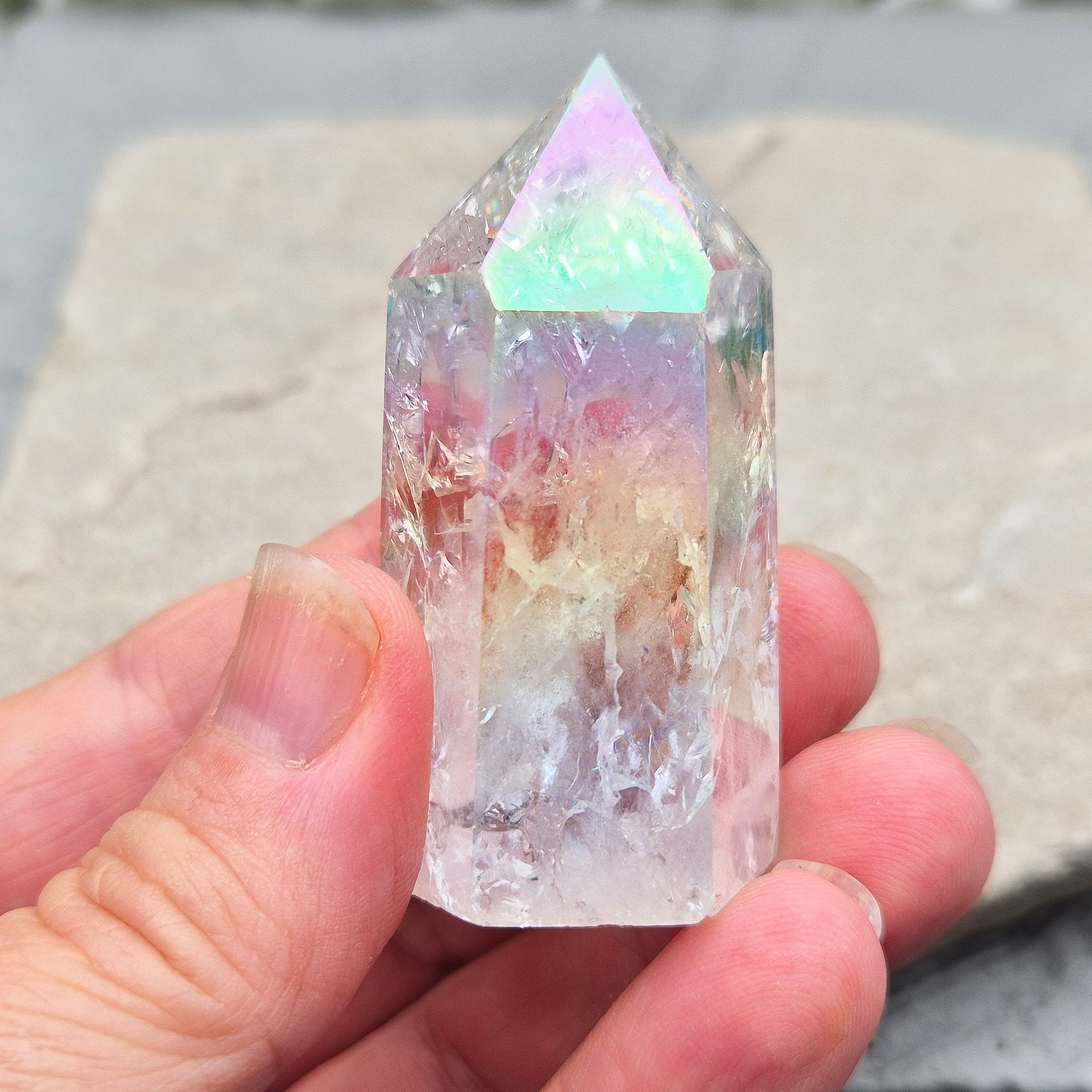 Aura Fire and Ice Quartz standing point with rainbow flashes and iridescent finish. A bright crystal for uplifting spaces, clearer thinking, and spiritual work.