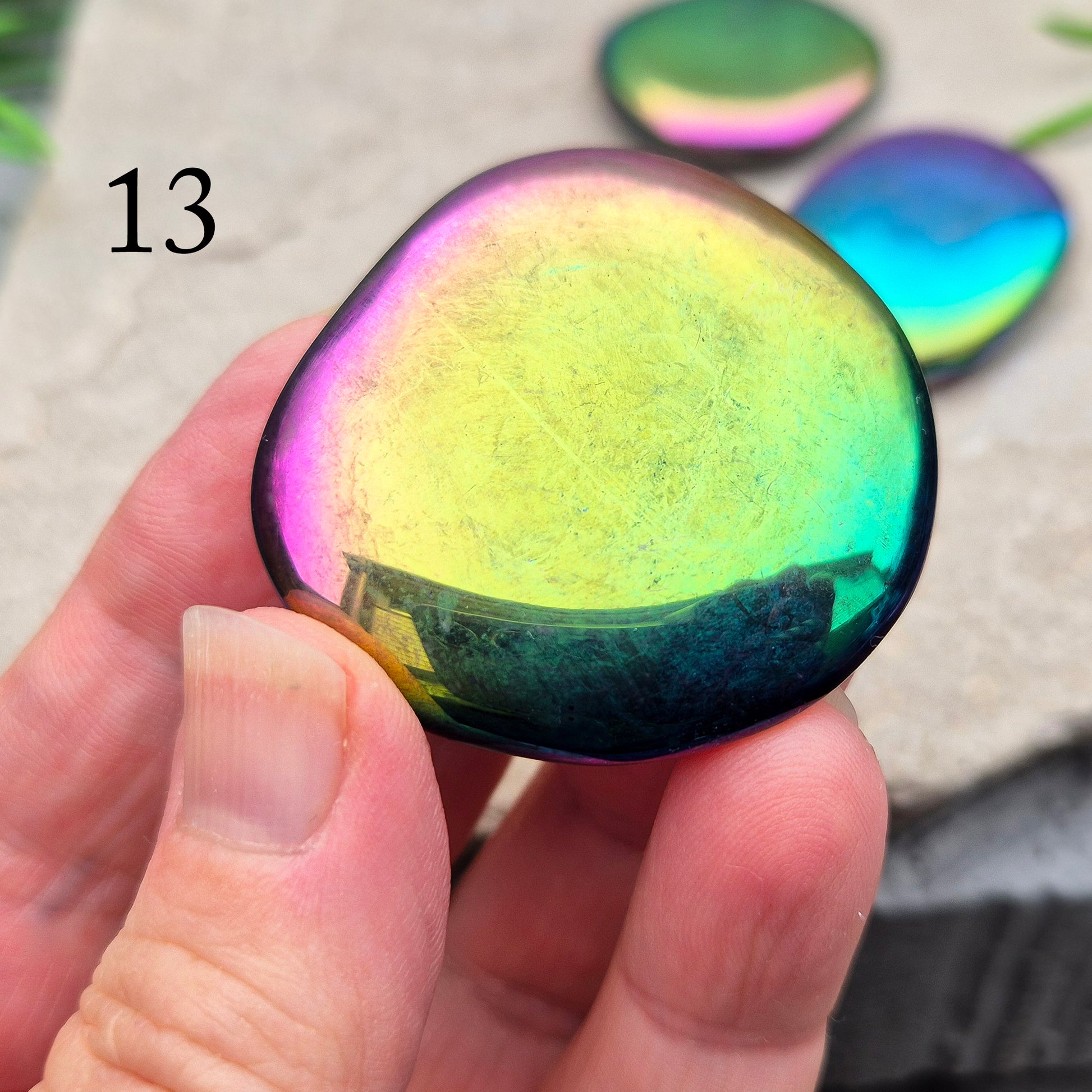 Discover our Titanium Aura Obsidian Palm Stones. This crystal calms anxiety and balances your energy and chakras. It protects against negative energy.