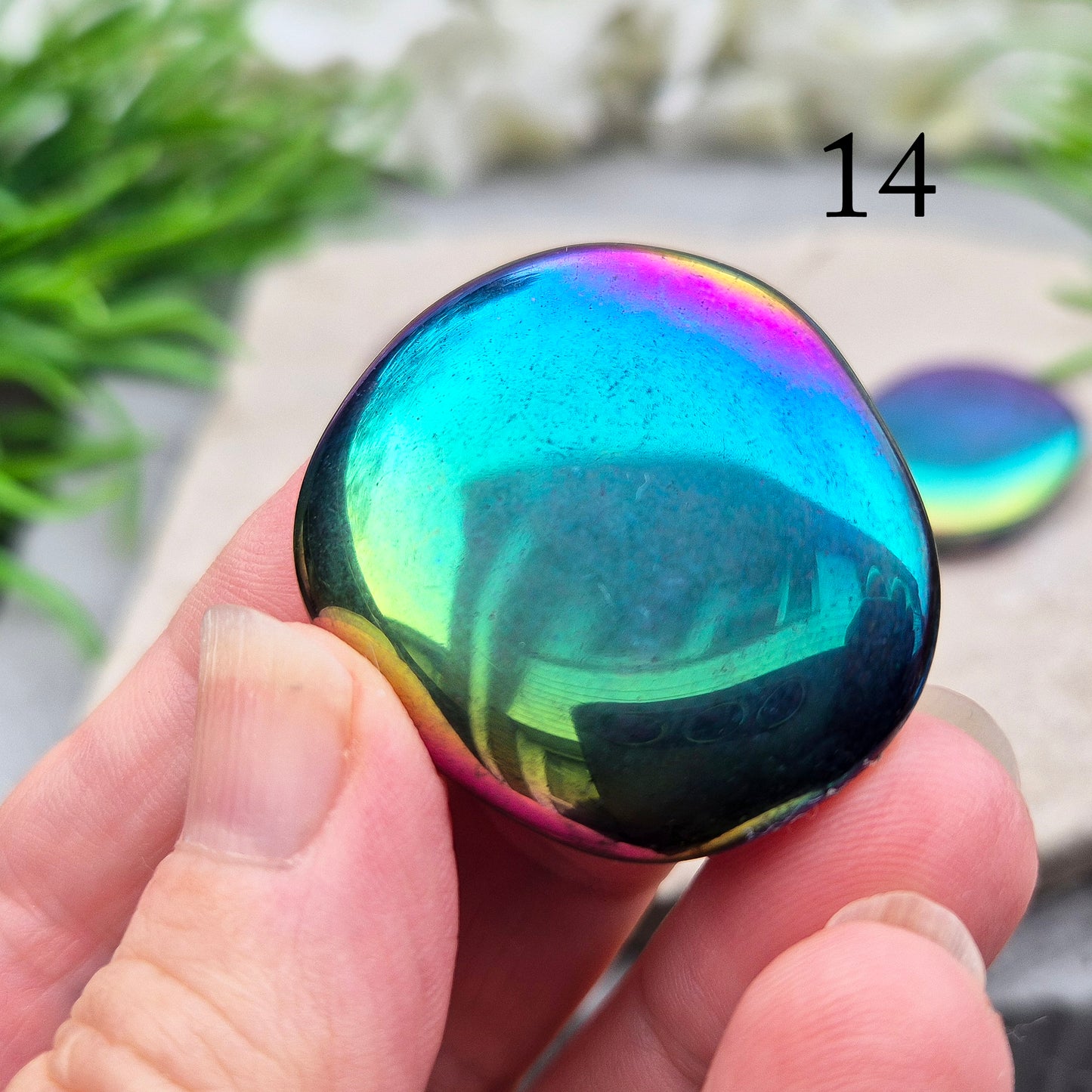 Discover our Titanium Aura Obsidian Palm Stones. This crystal calms anxiety and balances your energy and chakras. It protects against negative energy.