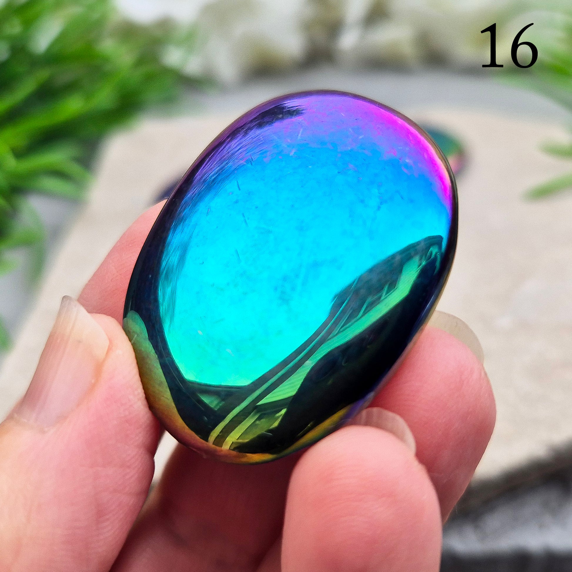 Discover our Titanium Aura Obsidian Palm Stones. This crystal calms anxiety and balances your energy and chakras. It protects against negative energy.