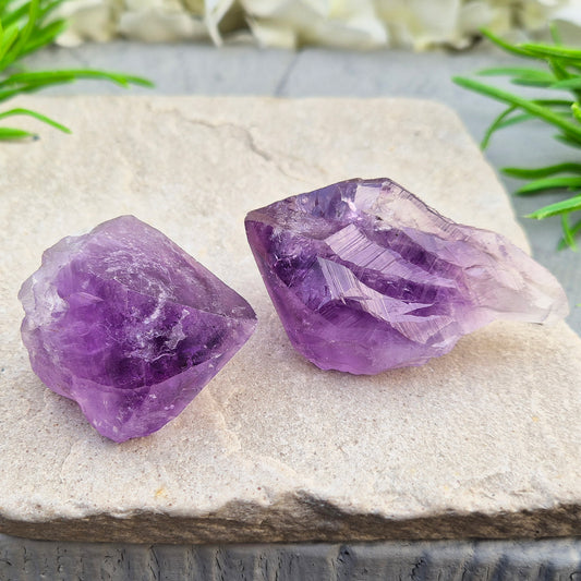 A pair of Amethyust Points with a natural Amethyst "root" formation from Brazil. The points have a polshhed point and natural body — a form sometimes called Amethyst Teeth because of its distinctive shape.